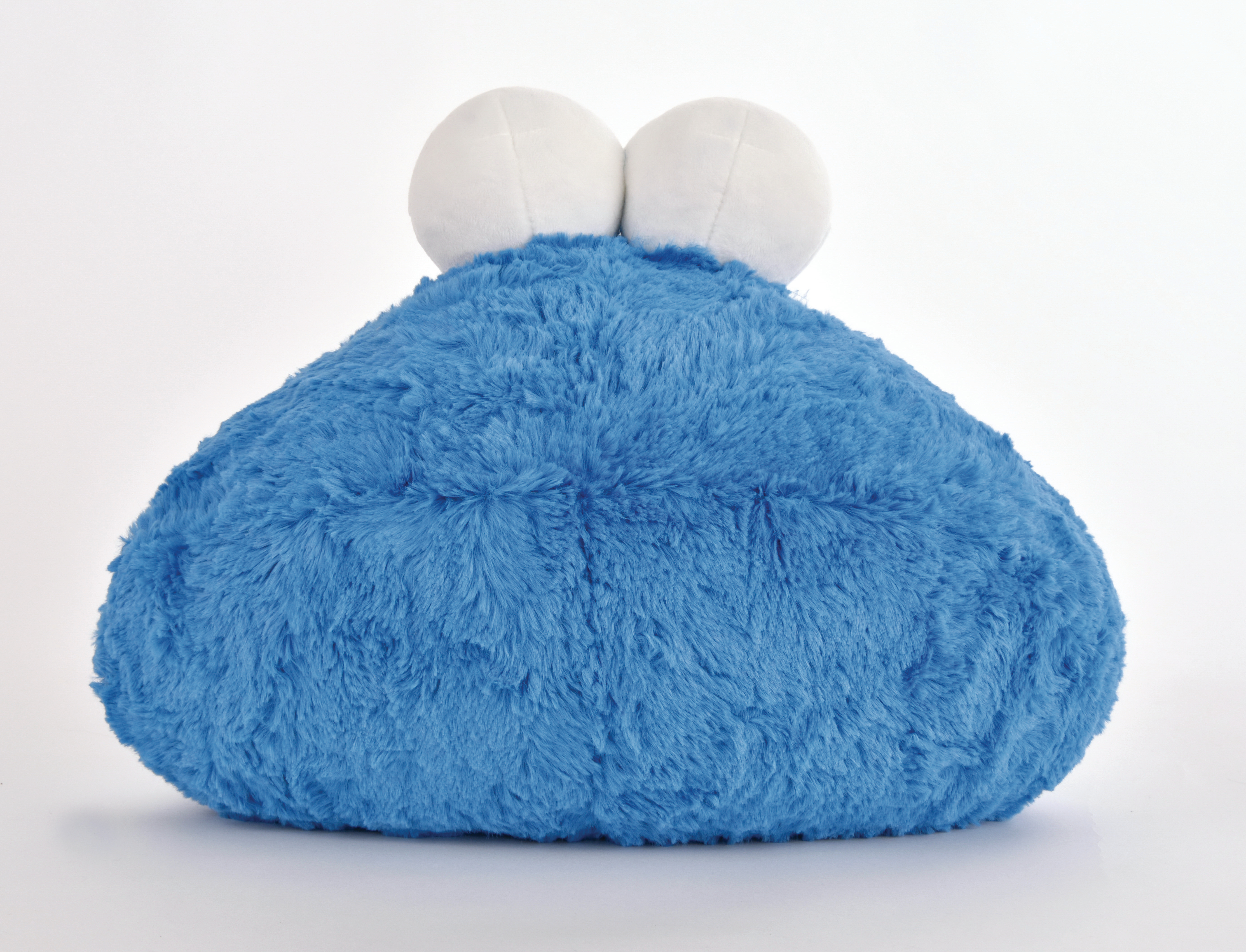 Ein blauer, pelziger Krümelmonster-Plüsch mit weißen Augen auf weißem Hintergrund.