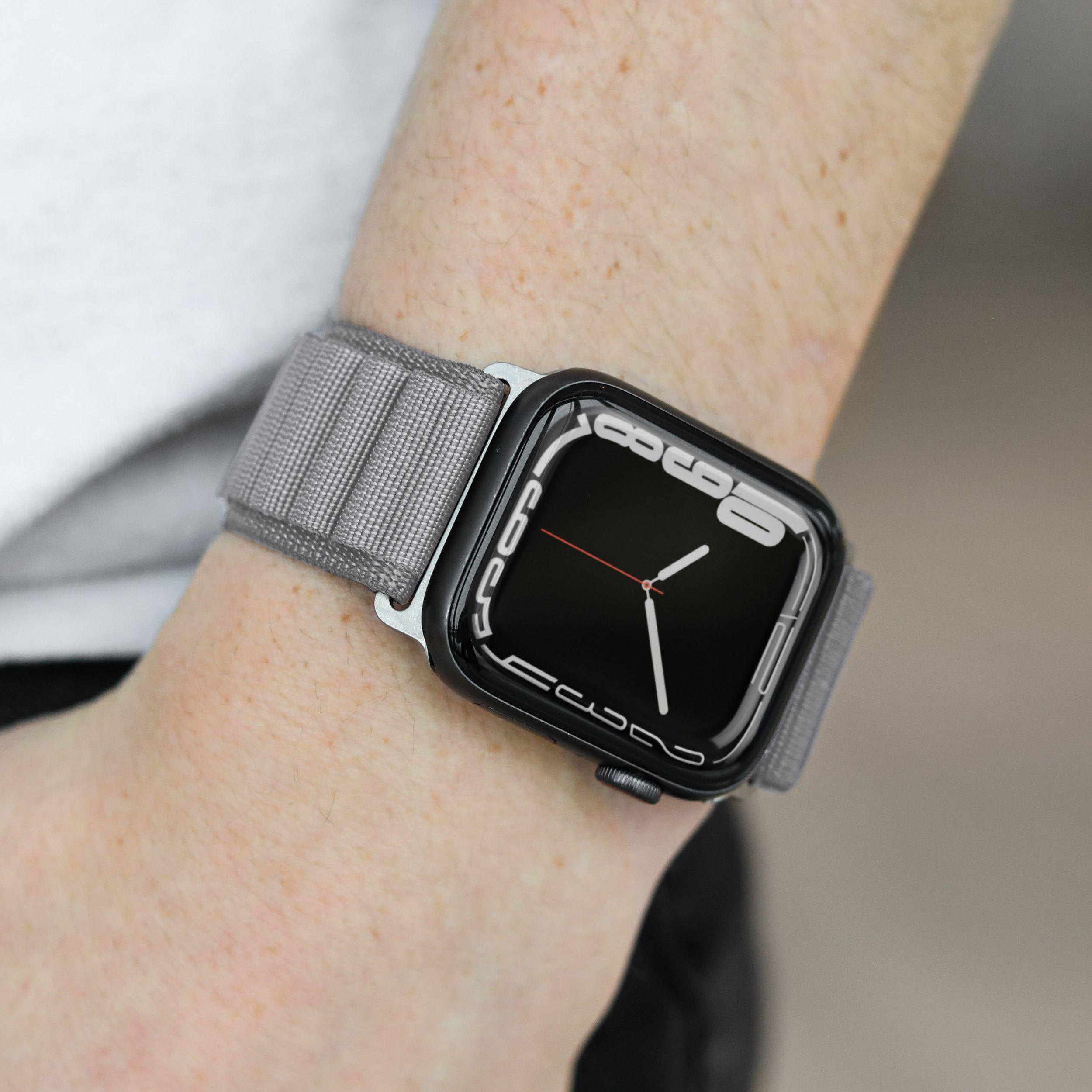 Person trägt eine Smartwatch. Die Uhr hat ein graues Armband und ein schwarzes Zifferblatt.