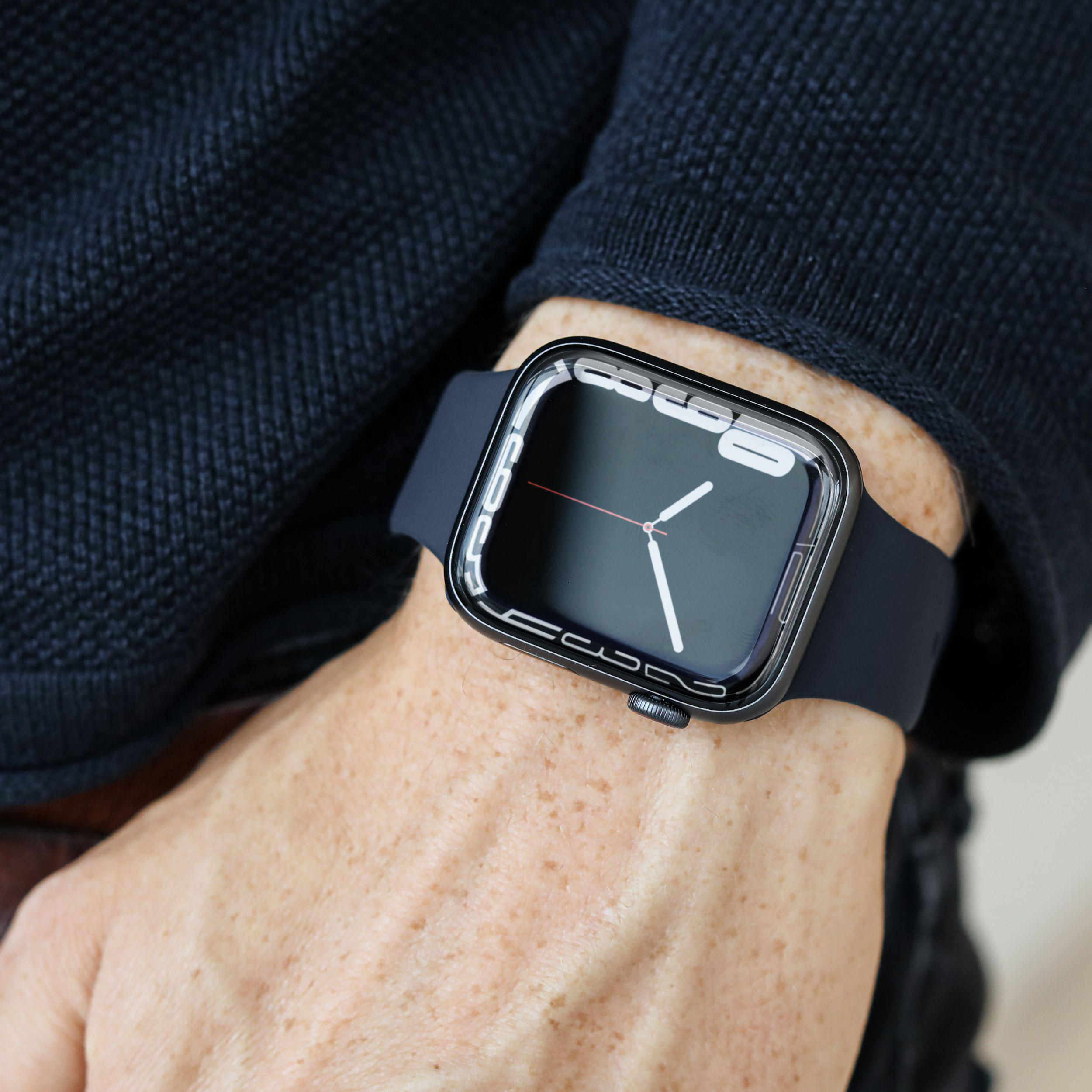 Ein Mann trägt eine schwarze Smartwatch mit schwarzem Armband. Die Uhr zeigt die Zeit an.