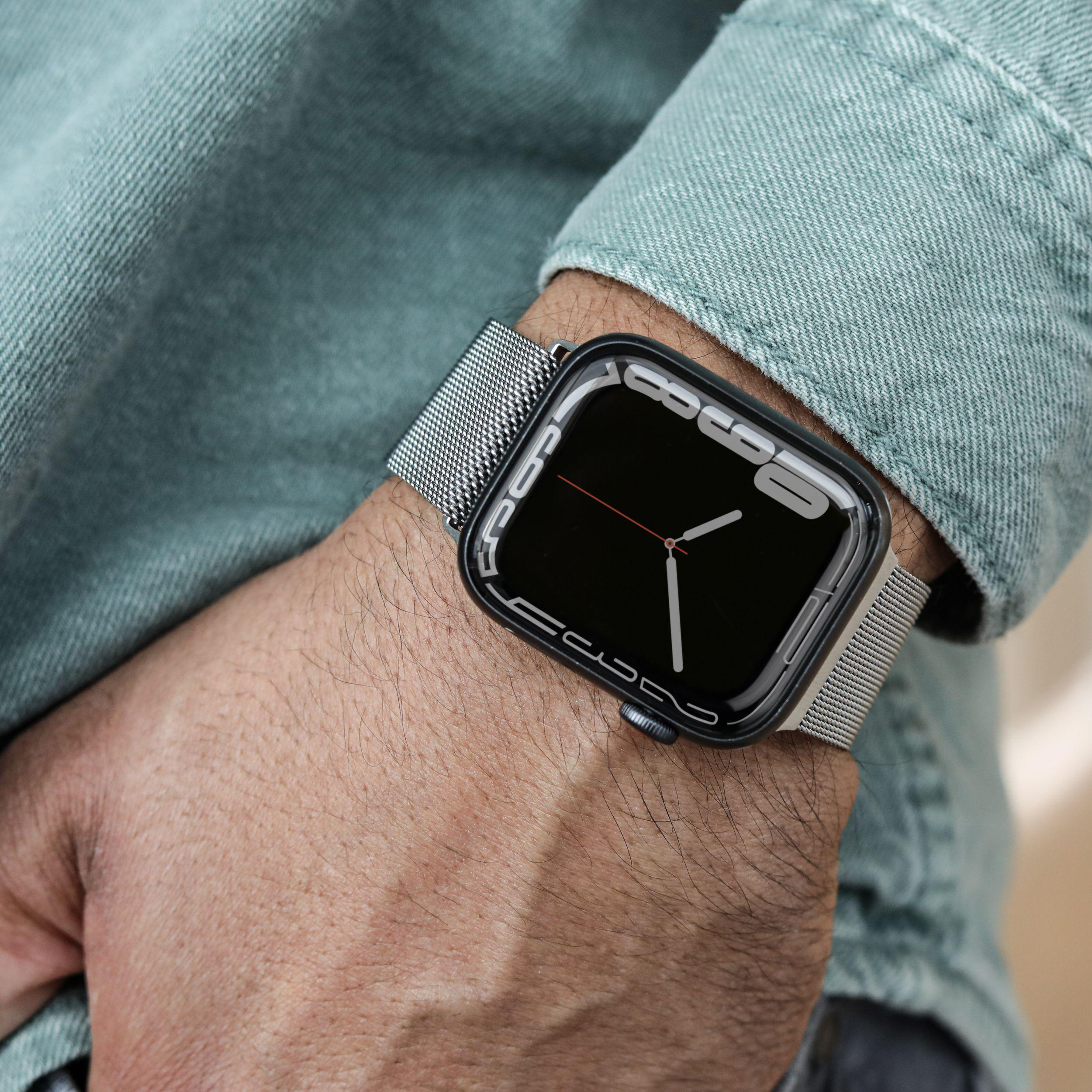 Das Handgelenk einer Person mit einer Apple Watch. Es hat einen schwarzen Bildschirm, der eine Uhr zeigt.