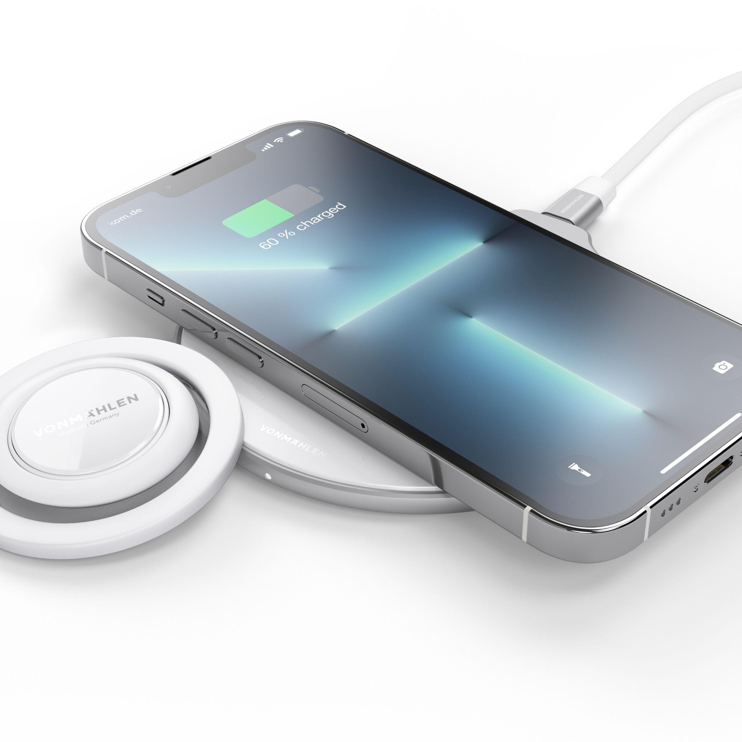 Ein Telefon, das drahtlos geladen wird, mit Ladepad und weißem Hintergrund.