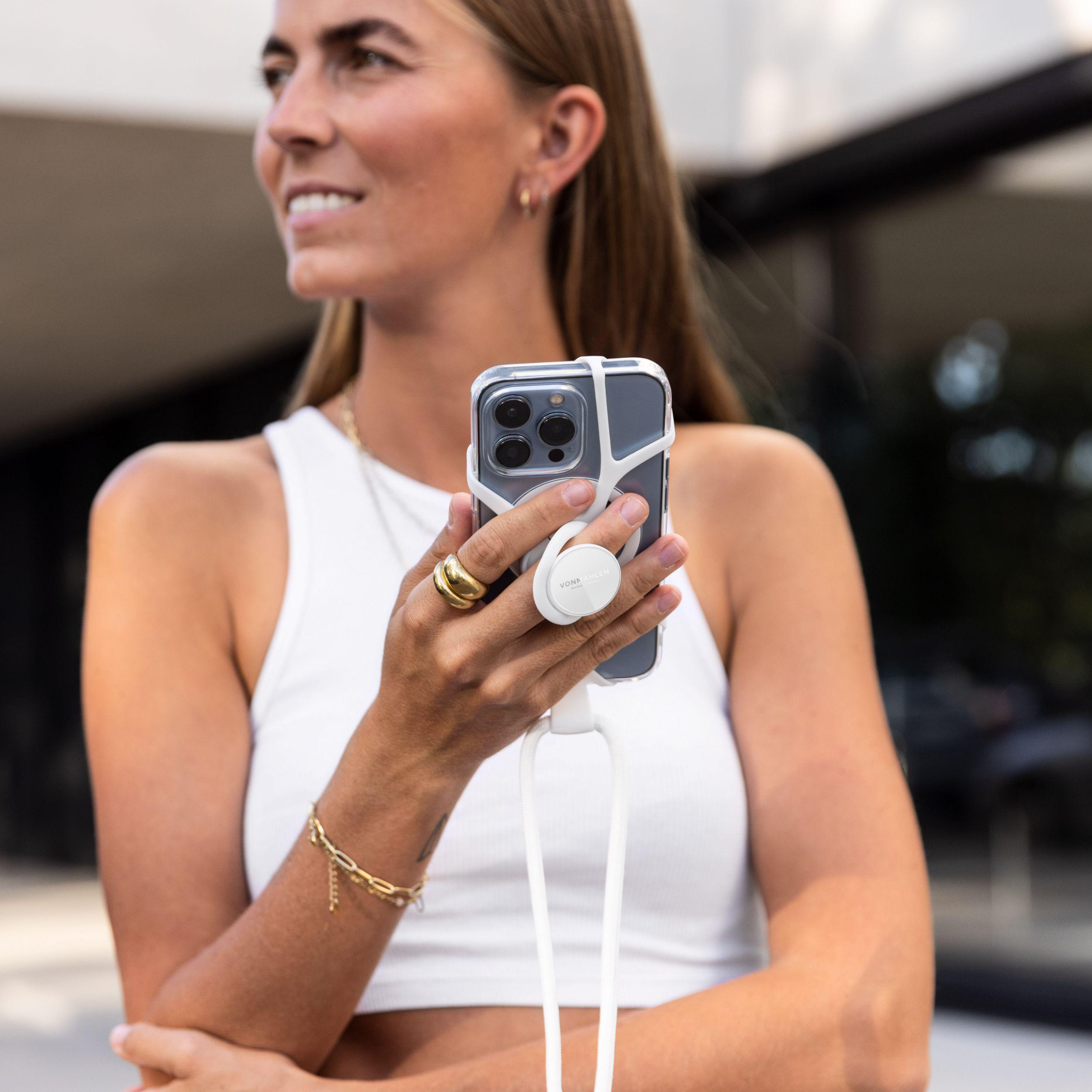 Frau in weißem Oberteil hält ein Telefon mit einem weißen Pop-Socket.