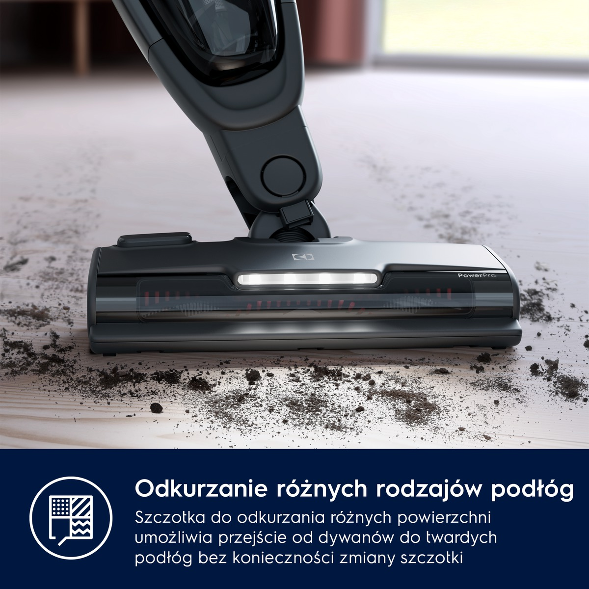Zbliżenie czarnej głowicy odkurzacza na drewnianej podłodze z brudem. Tekst na dole.
