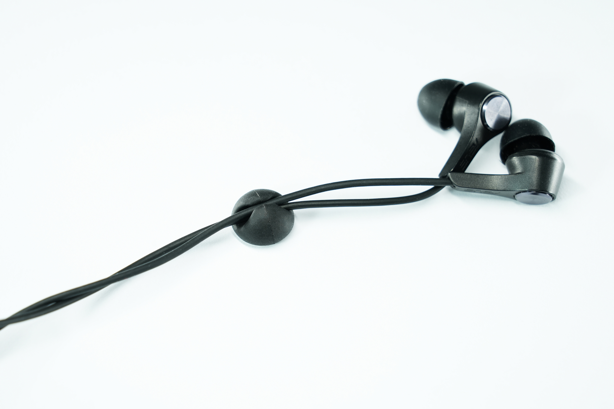 Auricolari neri con filo e un organizzatore di cavi nero.