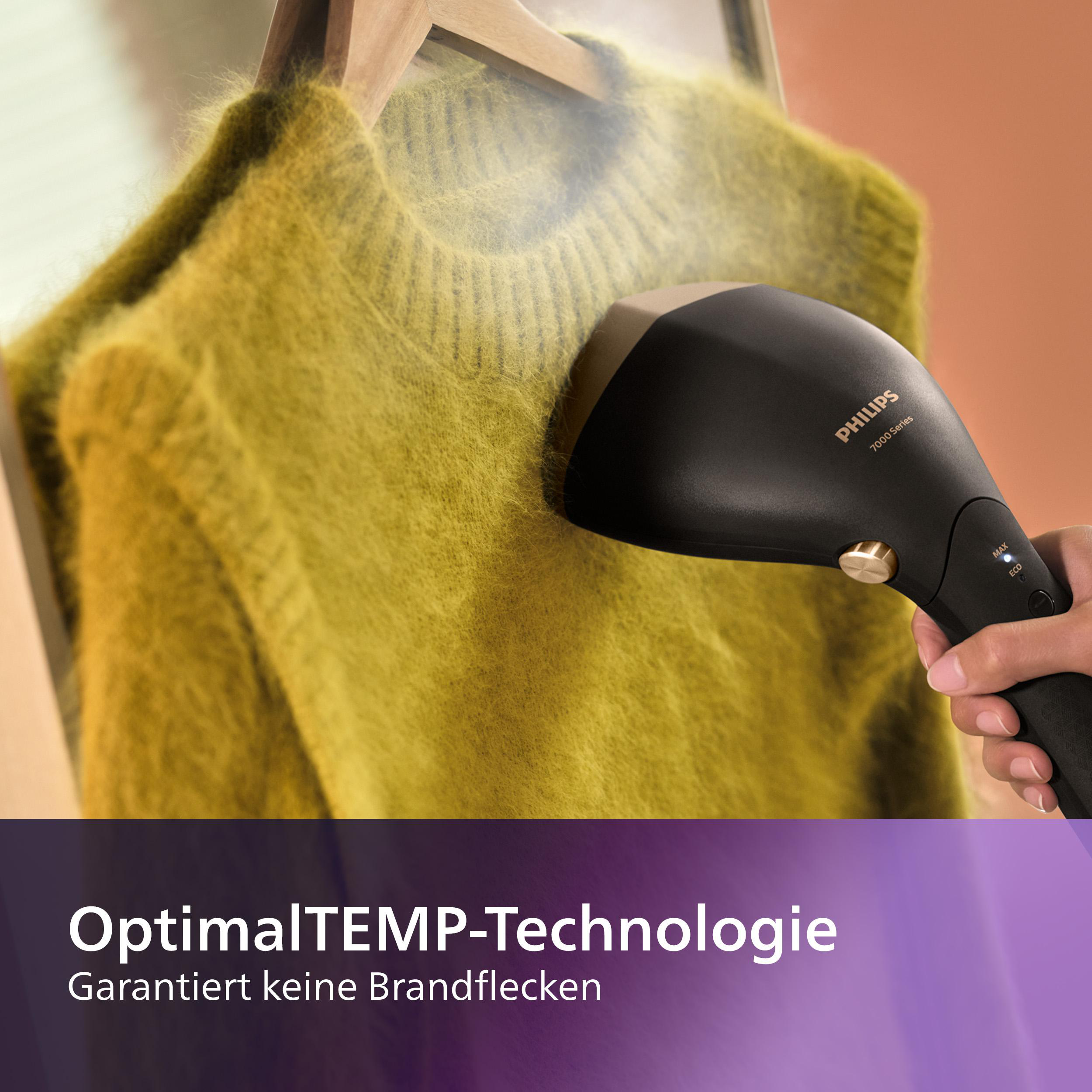 Ein schwarzer Steamer, der einen gelben Pullover auf einem Bügel bügelt.