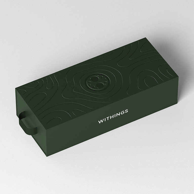Zöld doboz texturált fedéllel, a 'Withings' felirattal.