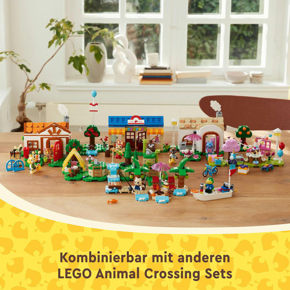 Lego-Set-Szene mit mehreren Gebäuden und Figuren auf einem Holztisch.