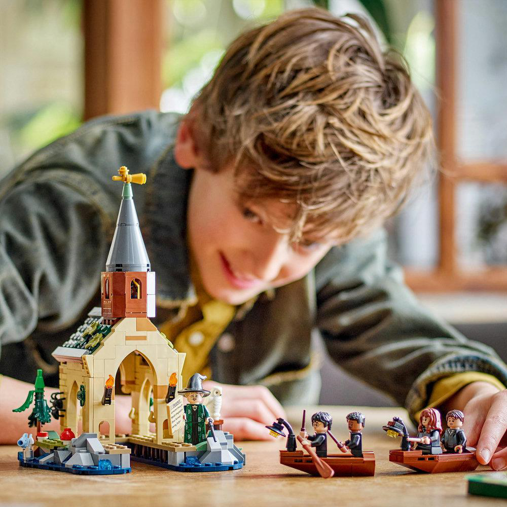 Ein Junge spielt mit einem Lego-Set mit einer Kirche und Booten mit Lego-Figuren.