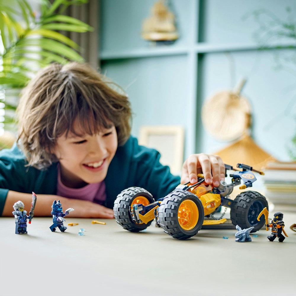 Ein Kind spielt mit einem Lego-Auto-Set, umgeben von Lego-Figuren.