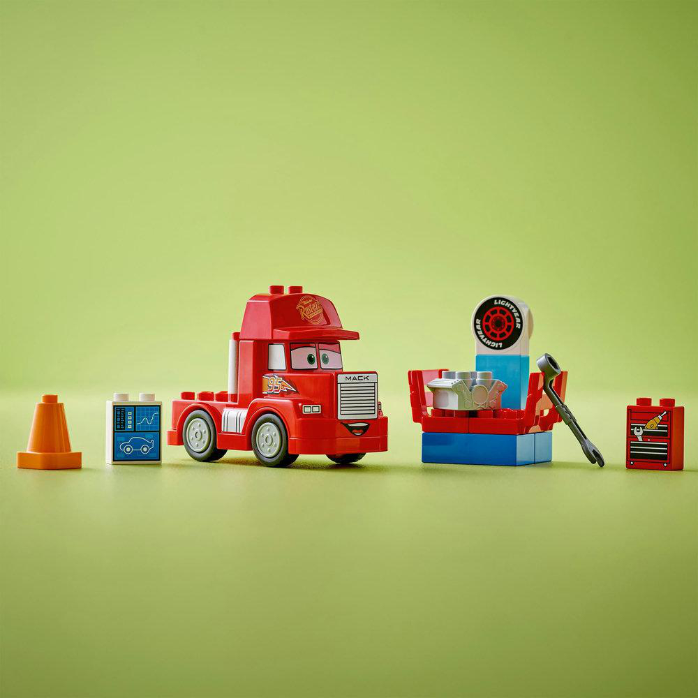 Ein roter Spielzeug-LKW und Bausteine liegen auf einer grünen Oberfläche.