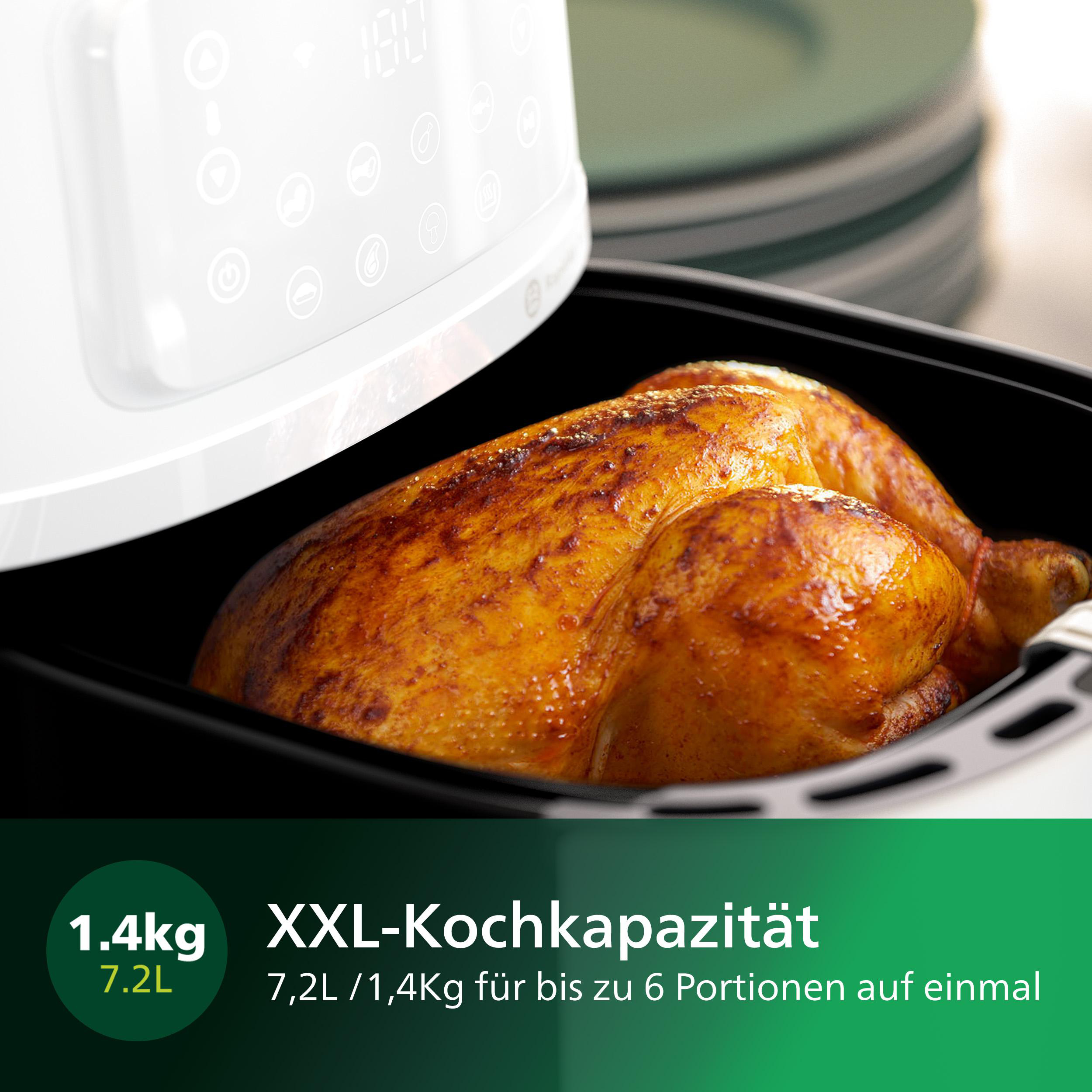 Ein Airfryer mit einem gekochten Huhn darin. Der Frittierer ist weiß. Das Huhn hat eine goldbraune Farbe.