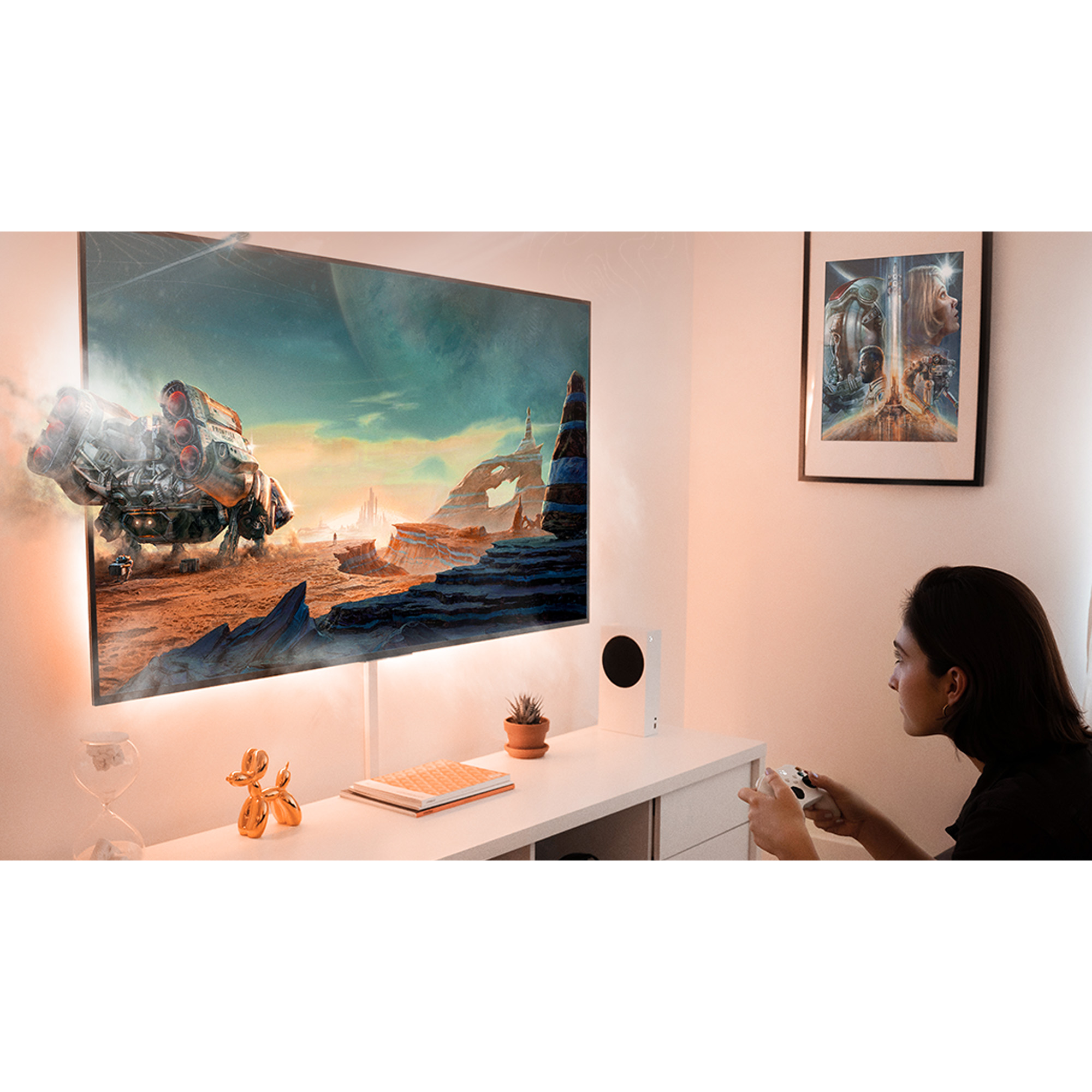 Una persona jugando un videojuego en un televisor de pantalla grande, con una consola blanca.
