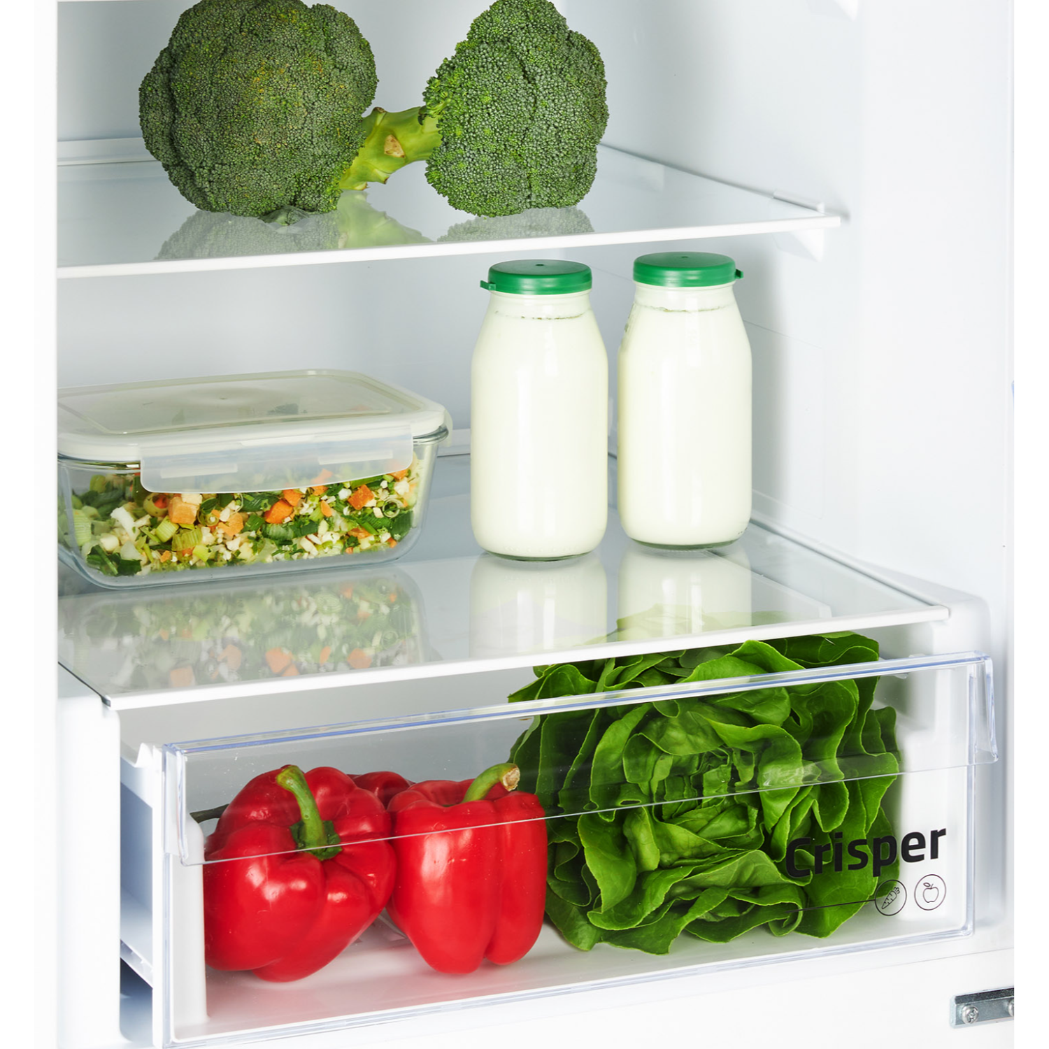 Inside a refrigerator, vegetables sit on shelves. Broccoli, peppers, lettuce, and milk bottles are visible.