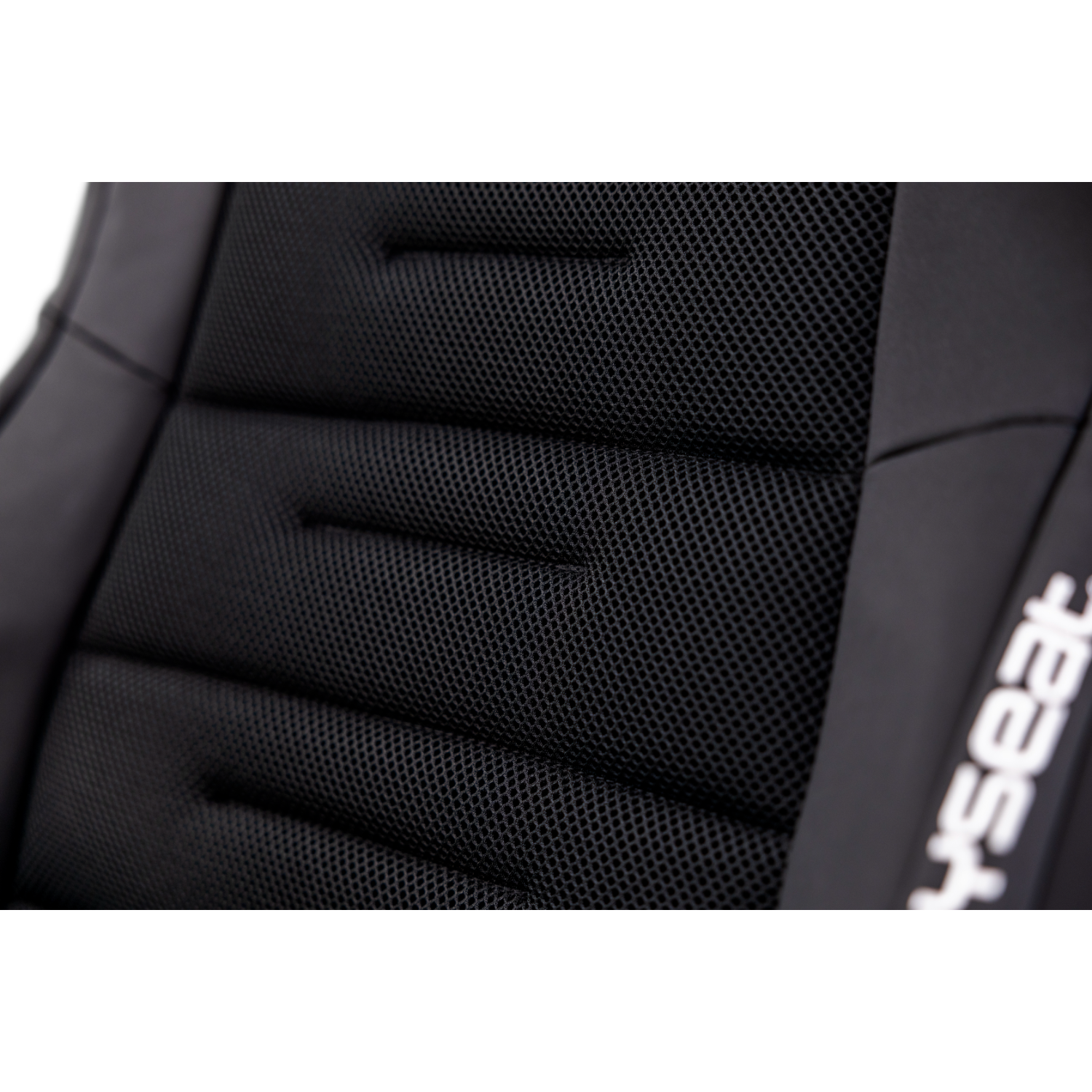 Close-up of a black gaming chair's backrest with mesh and stitching.