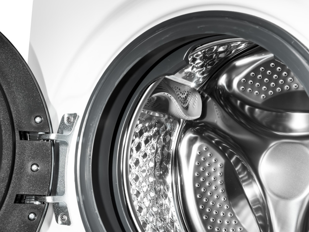 Binnenkant van wasmachine met open deur, close-up.