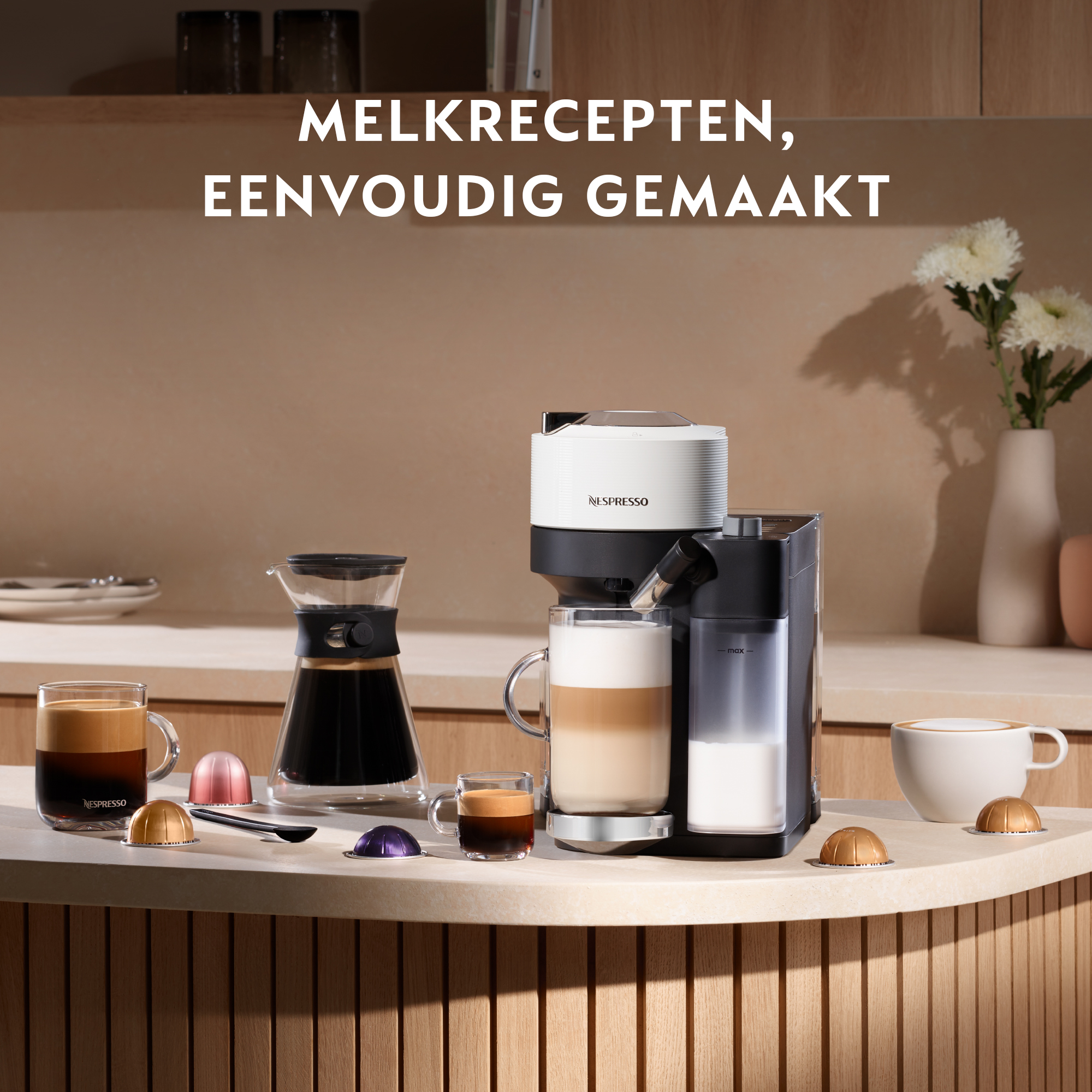 Coffee machine with coffee cups, capsules, and a glass carafe on a counter.