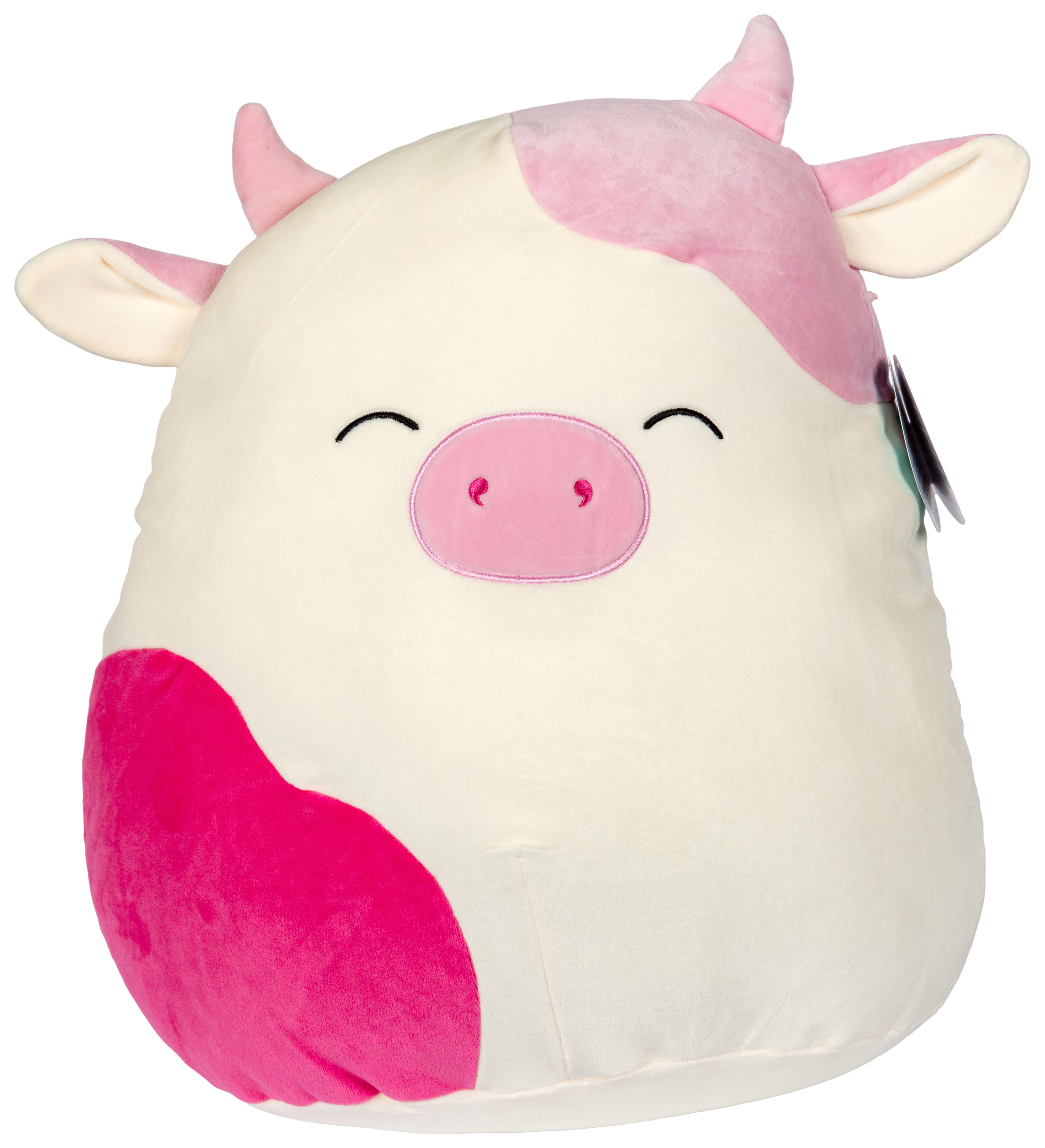Ein Stoffkuh. Weißer Körper, rosa Flecken, rosa Nase und rosa Hörner. Lächelndes Gesicht.