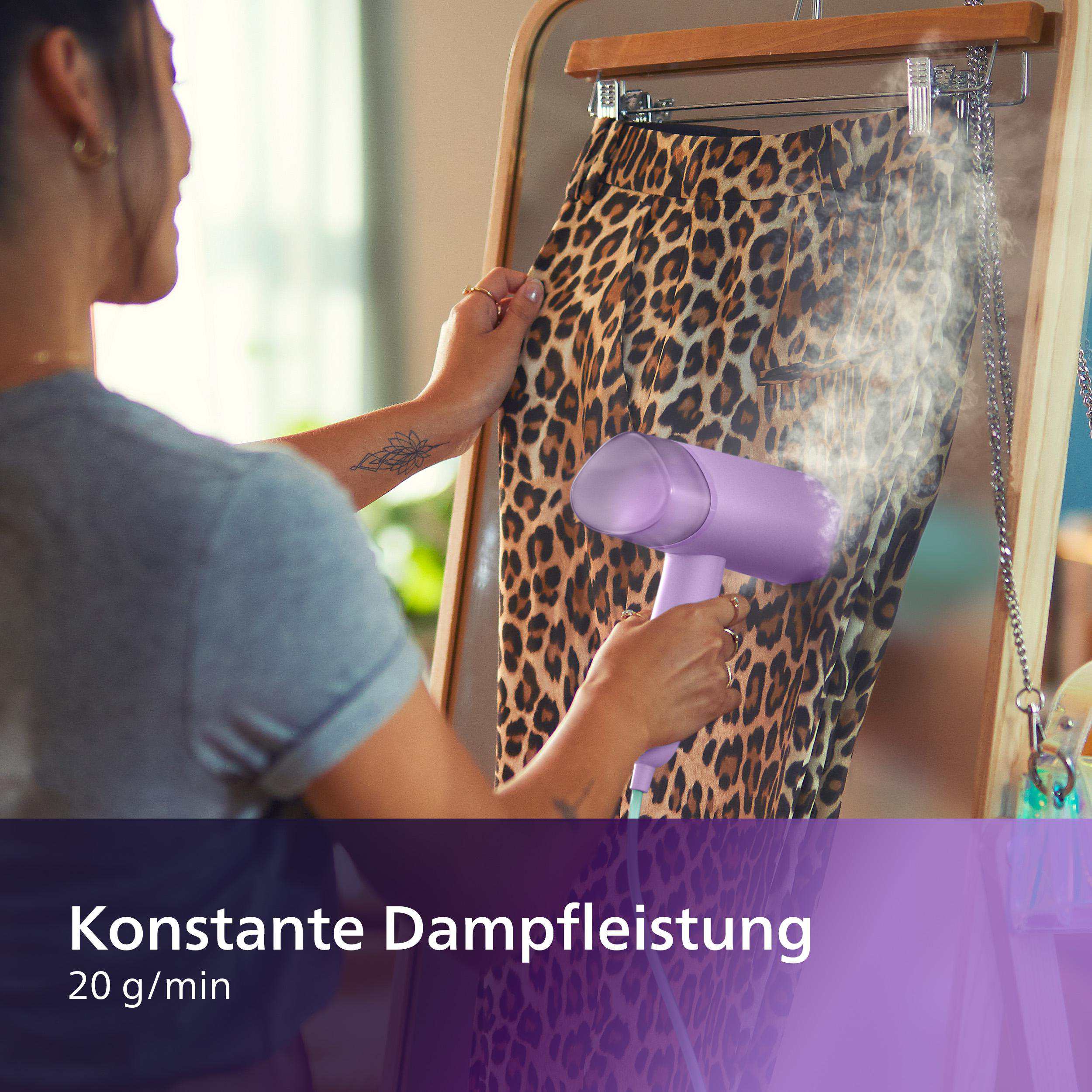 Frau dämpft Leopardenmusterhose mit einem lila Dampfgarer. Text: Konstante Dampfleistung.