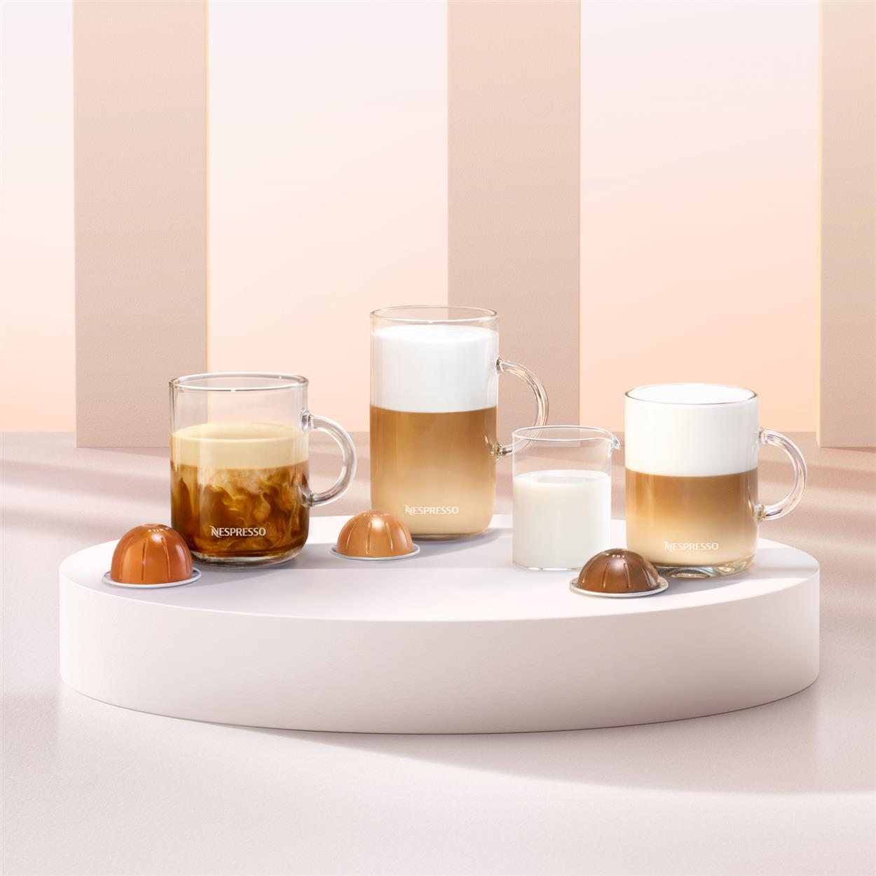 Boissons au café et capsules sur une plateforme blanche.