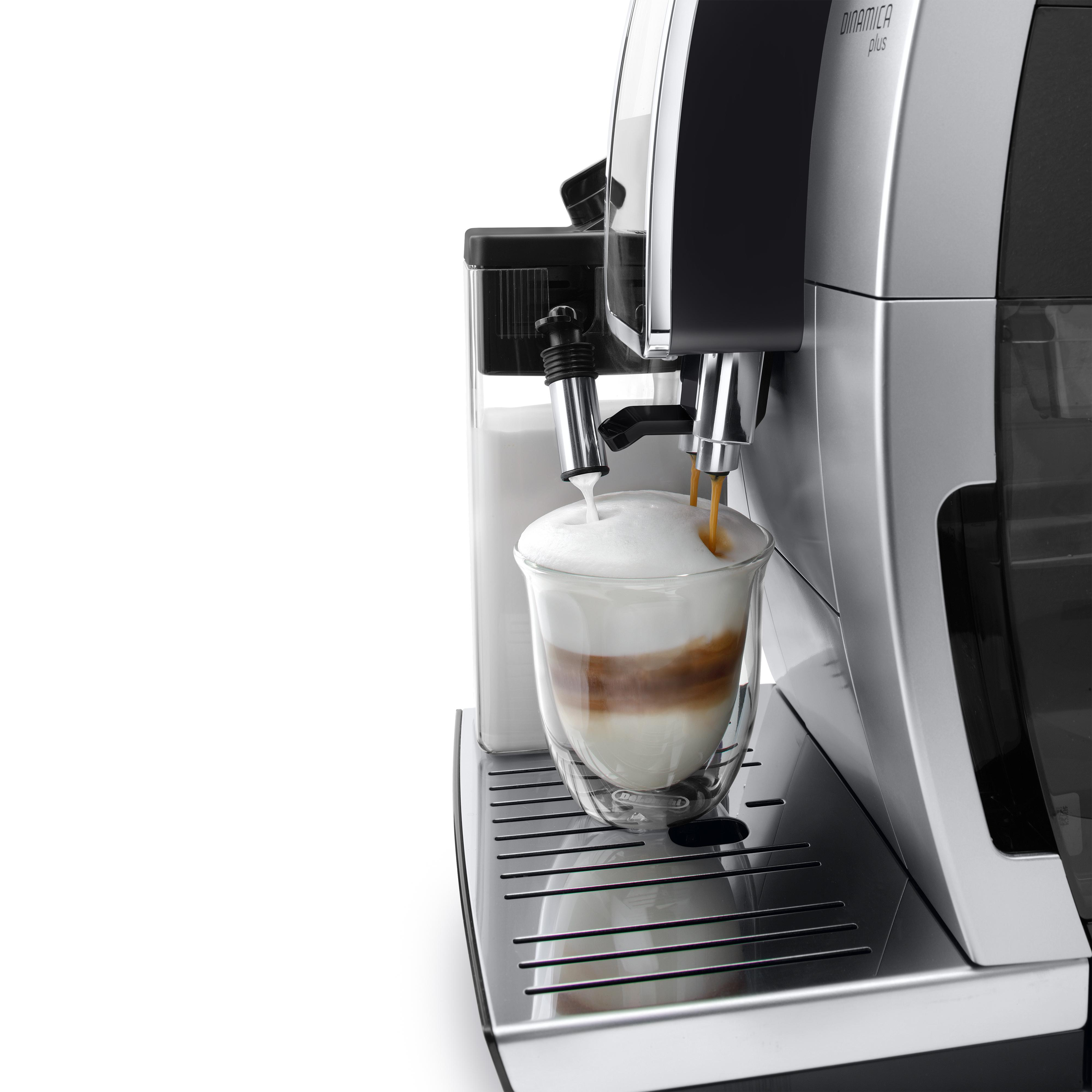 Ekspres do kawy dozuje kawę do szklanki z warstwami mleka i kawy.