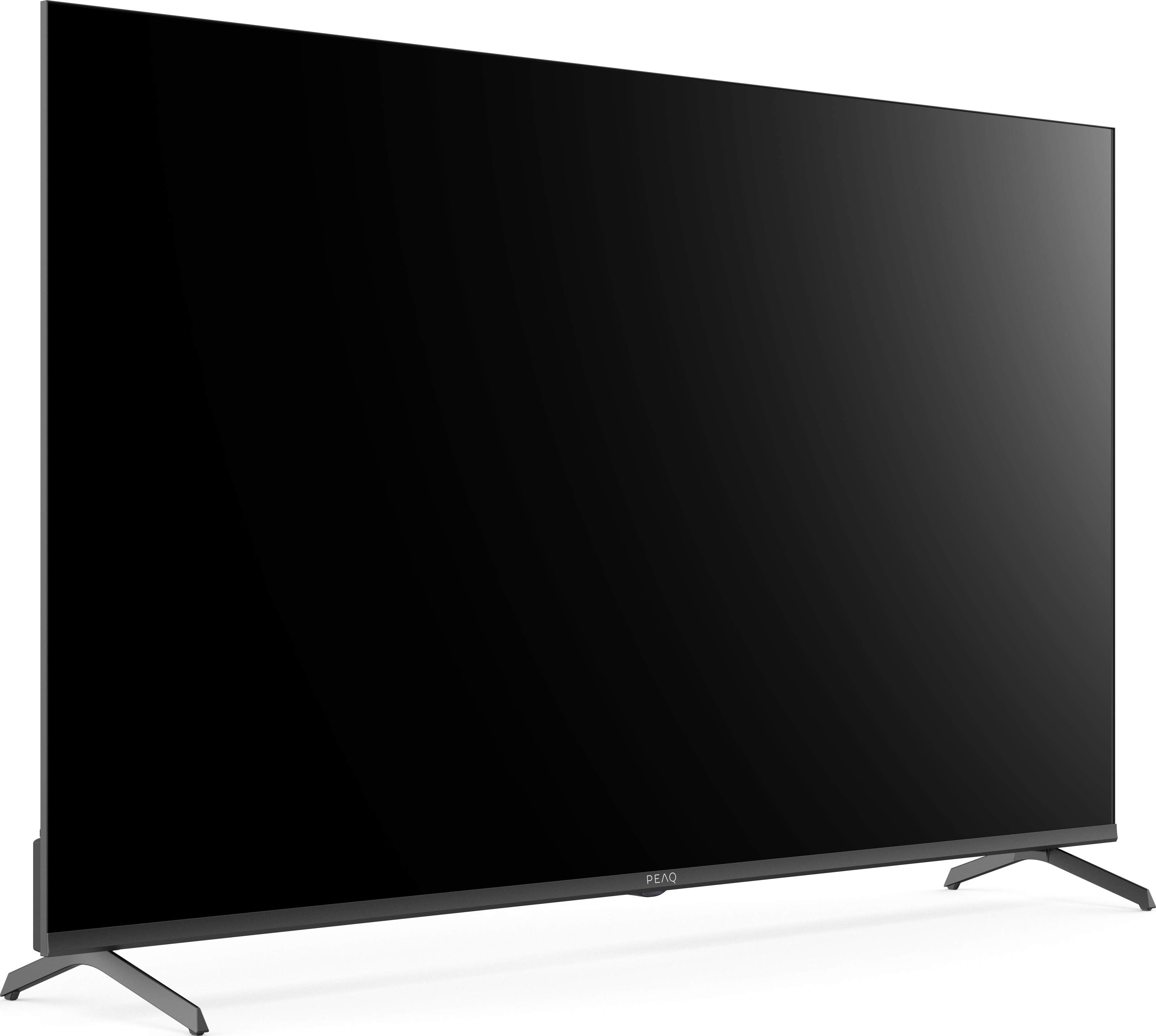 Ein großer schwarzer Fernseher, der auf zwei Beinen steht, mit dunklem Bildschirm. Der Markenname PEAQ ist sichtbar.