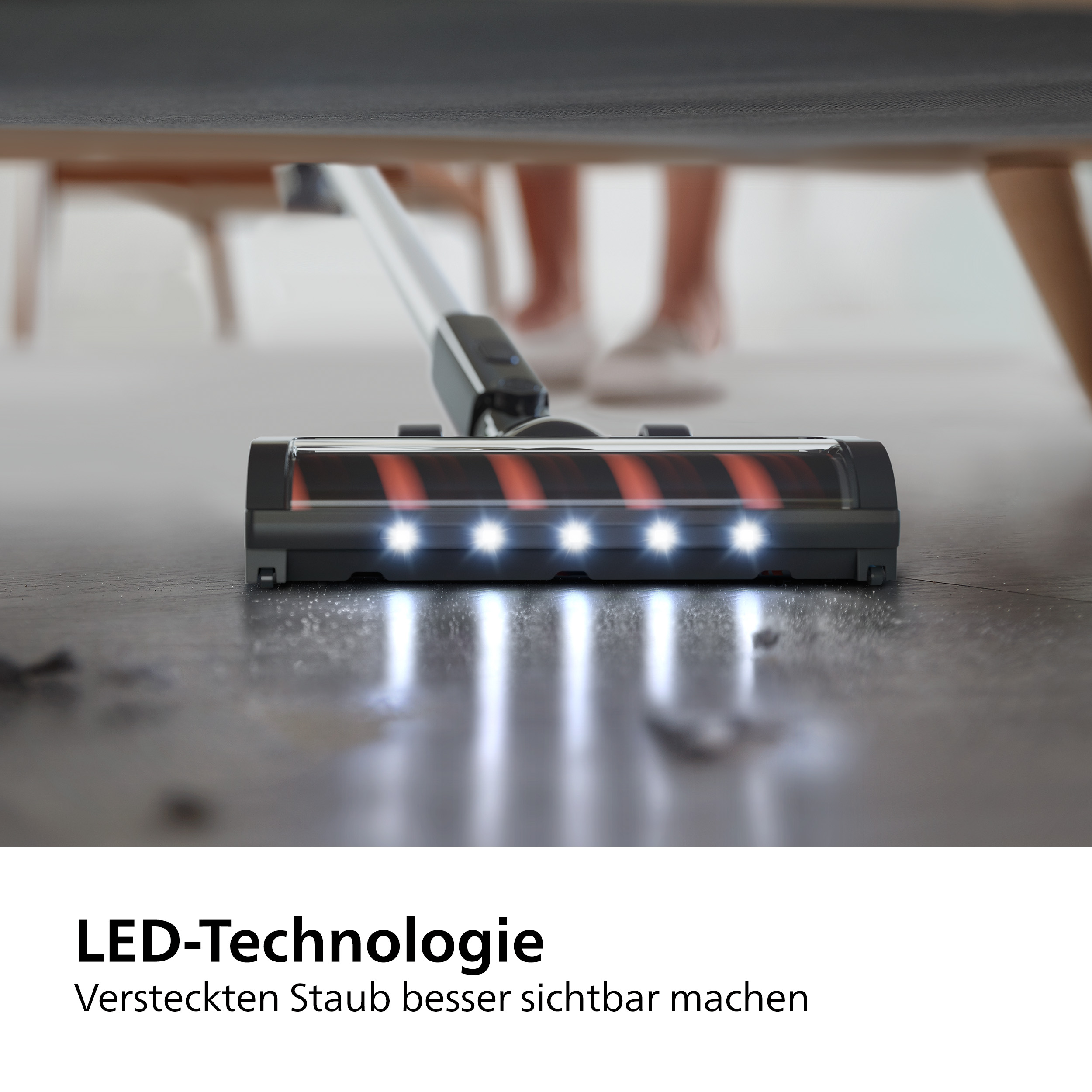 Nahaufnahme eines Staubsaugerkopfes mit LED-Leuchten, der einen Boden reinigt. Die Lichter sind an.