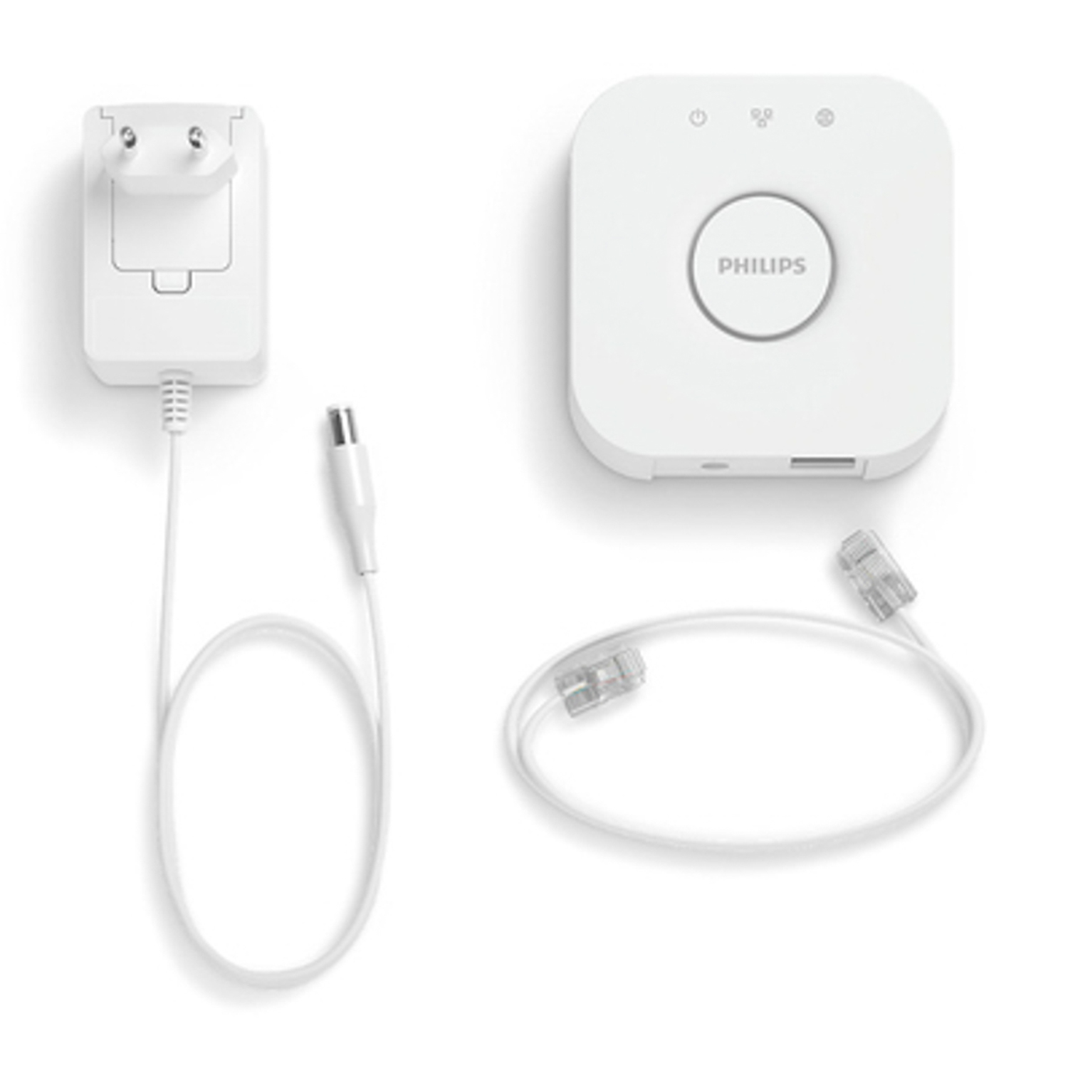 Un set Philips Hue Bridge con spina, cavo di alimentazione e cavo di rete.