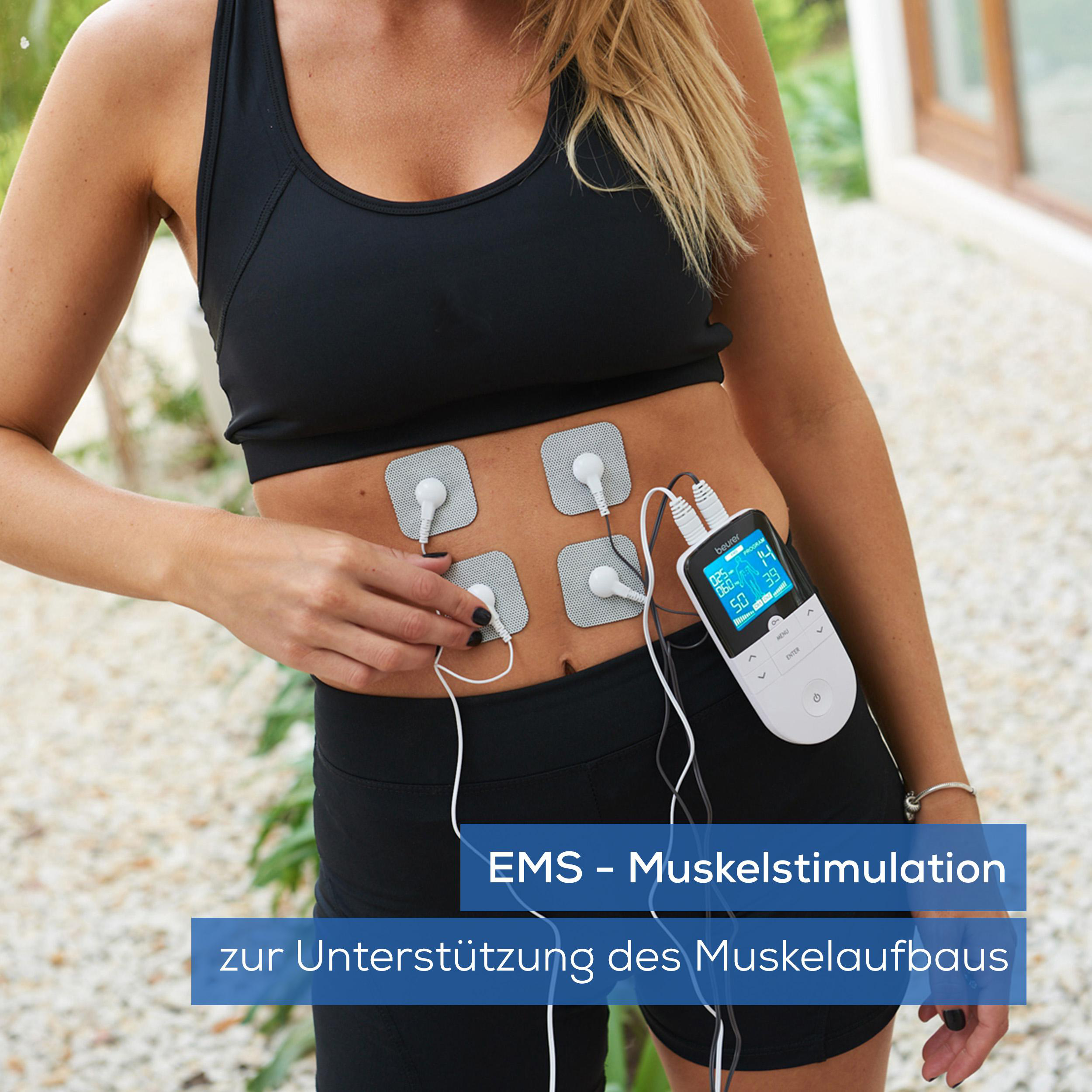Eine Frau benutzt ein EMS-Gerät an ihrem Bauch, um Muskeln zu stimulieren.