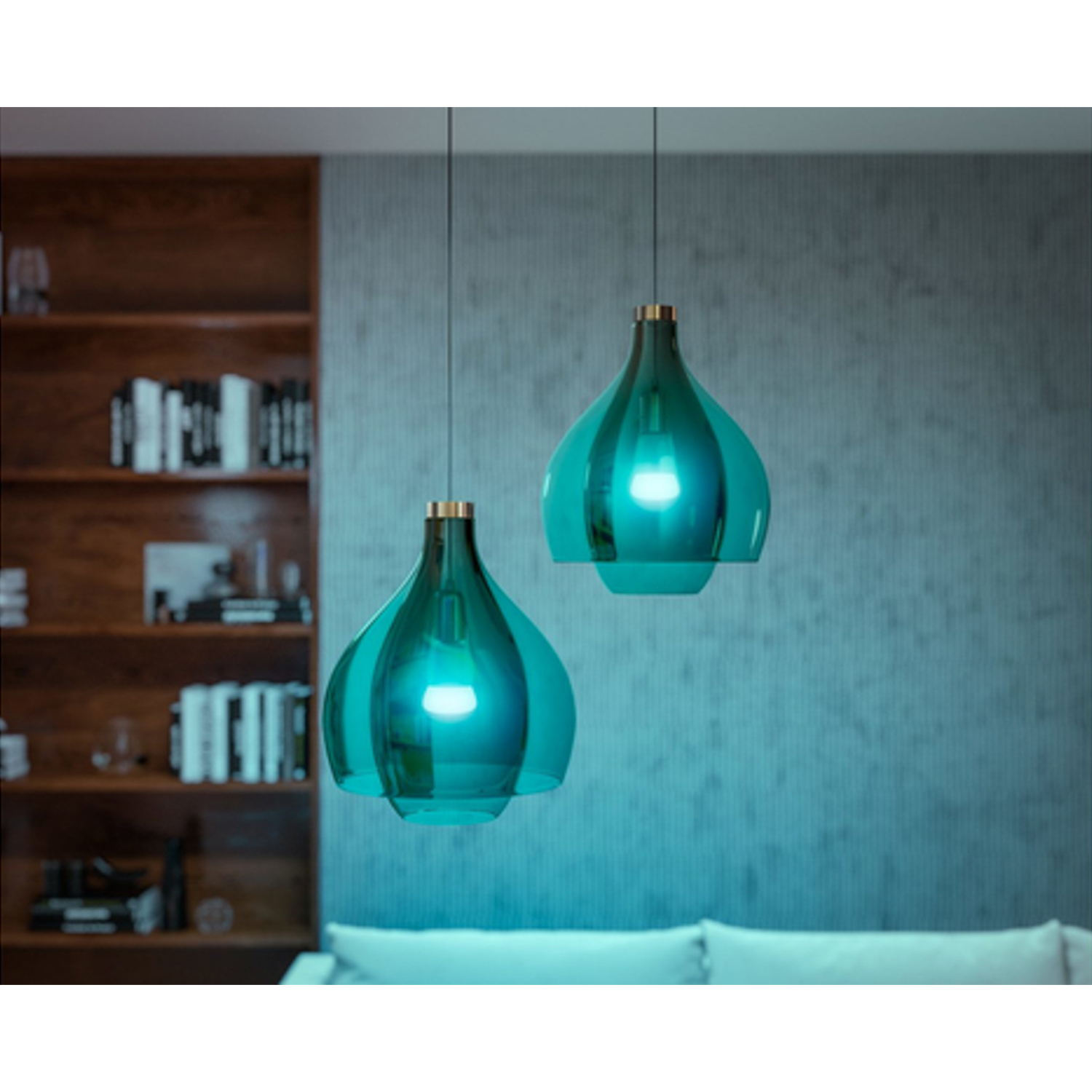 Due lampade a sospensione turchesi appese in una stanza con parete blu.