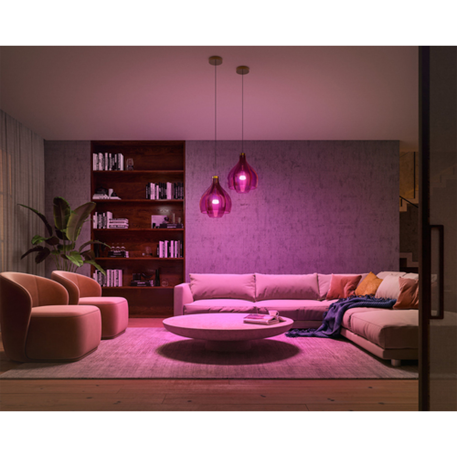 Soggiorno con illuminazione rosa. Due lampade rosa sono appese, un divano, sedie e un tavolo rotondo sono presenti.