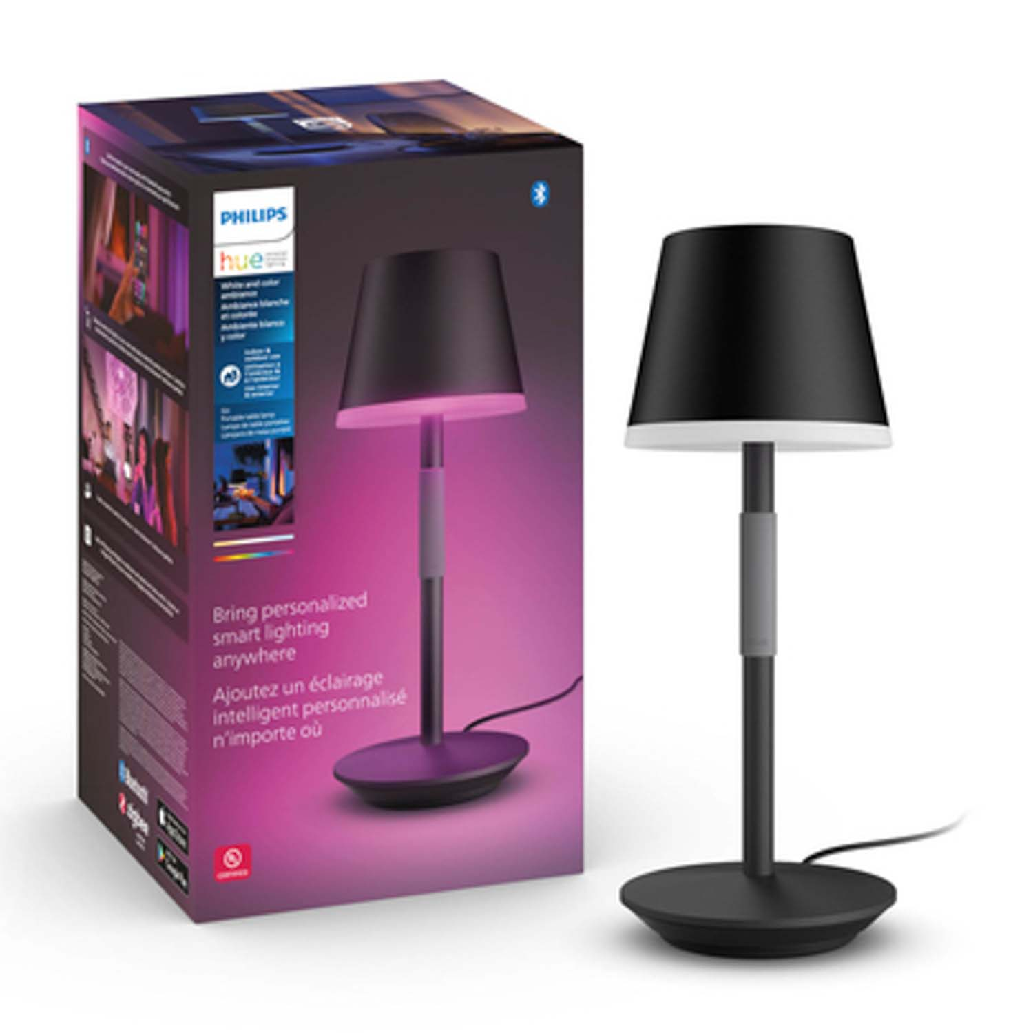 Una lampada nera con un paralume nero accanto a una scatola. La lampada ha una luce viola.