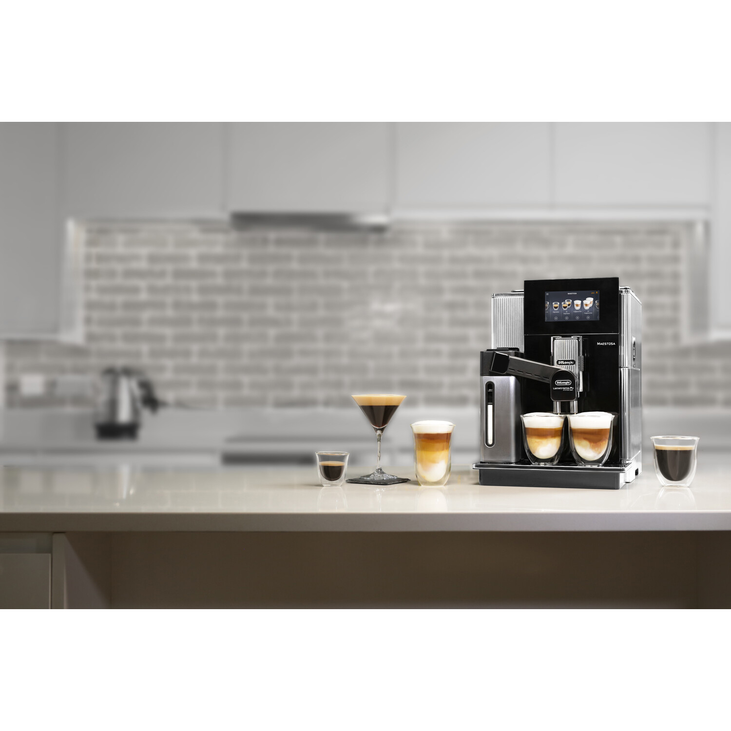 Macchina per espresso con bevande e bicchieri da caffè su un piano di lavoro, sfondo cucina.