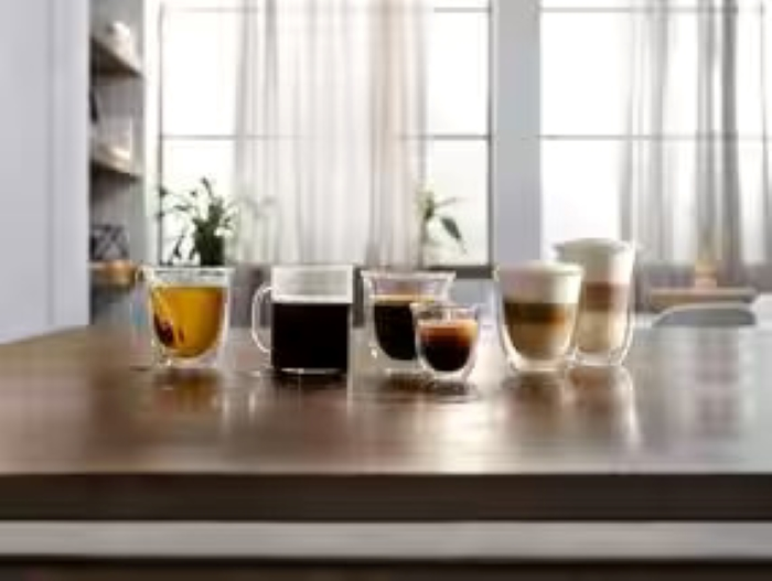 Asortyment kawy i herbaty w różnych szklankach na stole. Tło jest rozmyte.