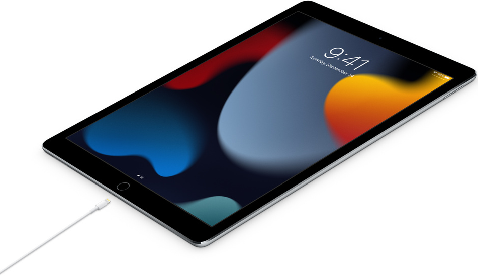 Un iPad est branché avec un câble de chargement. L'écran affiche l'heure et la date.