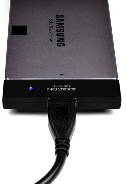 Egy Samsung SSD csatlakoztatva egy Axagon Slimport 6-hoz USB-kábellel, fehér háttéren.