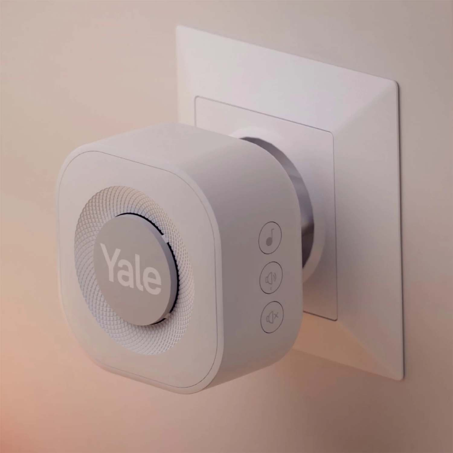 Spina intelligente Yale bianca con pulsanti. È collegata a una presa a muro bianca.