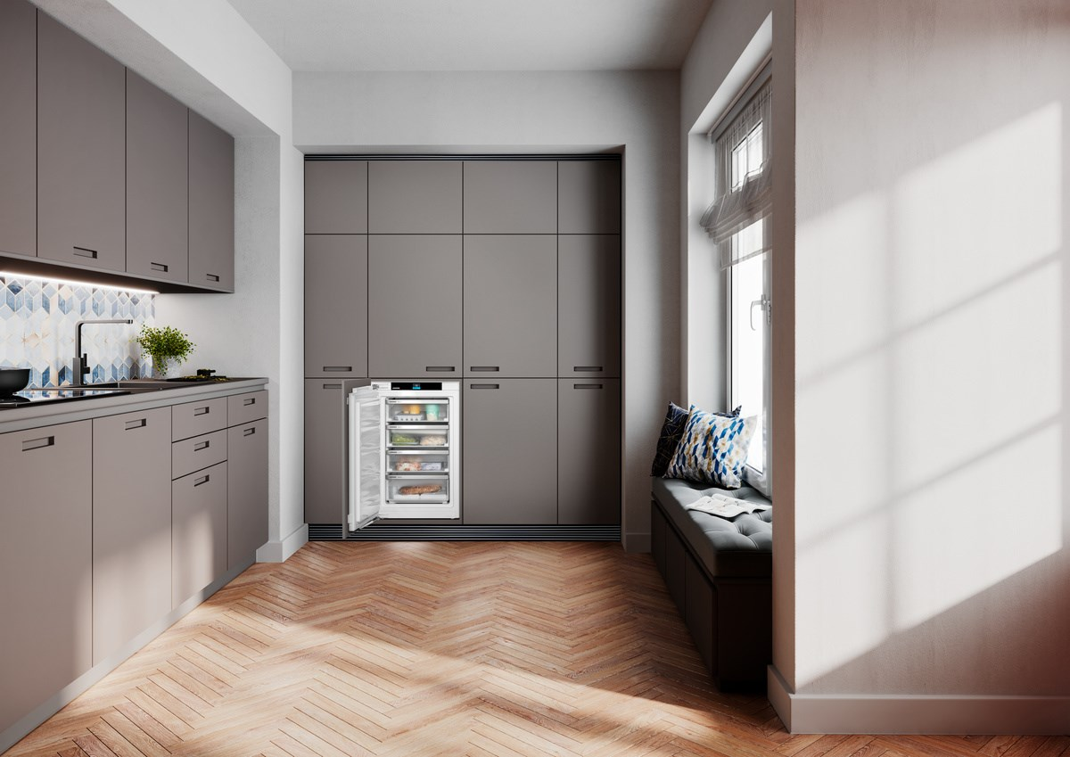 Eine moderne Küche mit grauen Schränken, einem Einbaukühlschrank und einer Fensterbank.