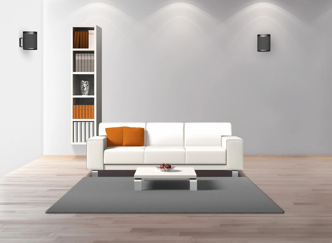Wohnzimmer mit weißem Sofa, orangefarbenem Kissen, grauem Teppich und Bücherregalen.