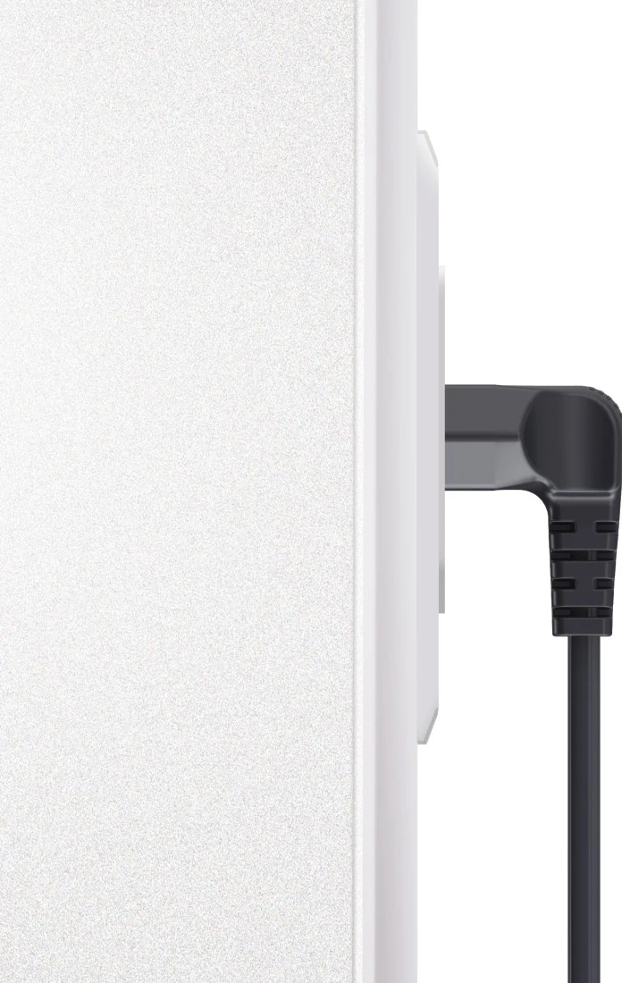 Eine weiße Steckdose mit einem schwarzen, abgewinkelten Stecker. Nahaufnahme.