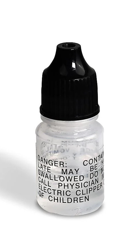 Mała, przezroczysta butelka z czarną zakrętką. Zawiera płyn. Tekst: Danger, May be swallowed, etc.