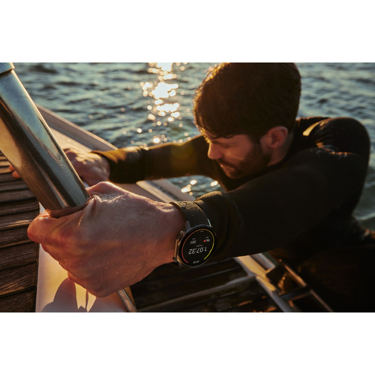Homme dans l'eau, avec montre, s'accrochant au bateau. Eau en arrière-plan.