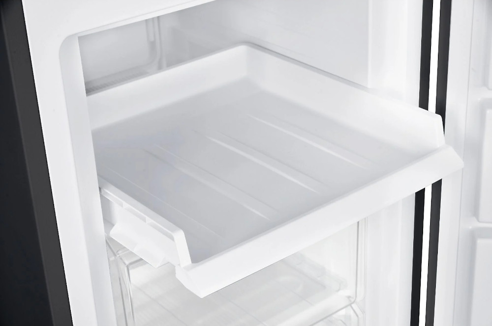 Een wit koelkastinterieur met een uittrekbare lade, die de binnenkant van de koelkast laat zien.