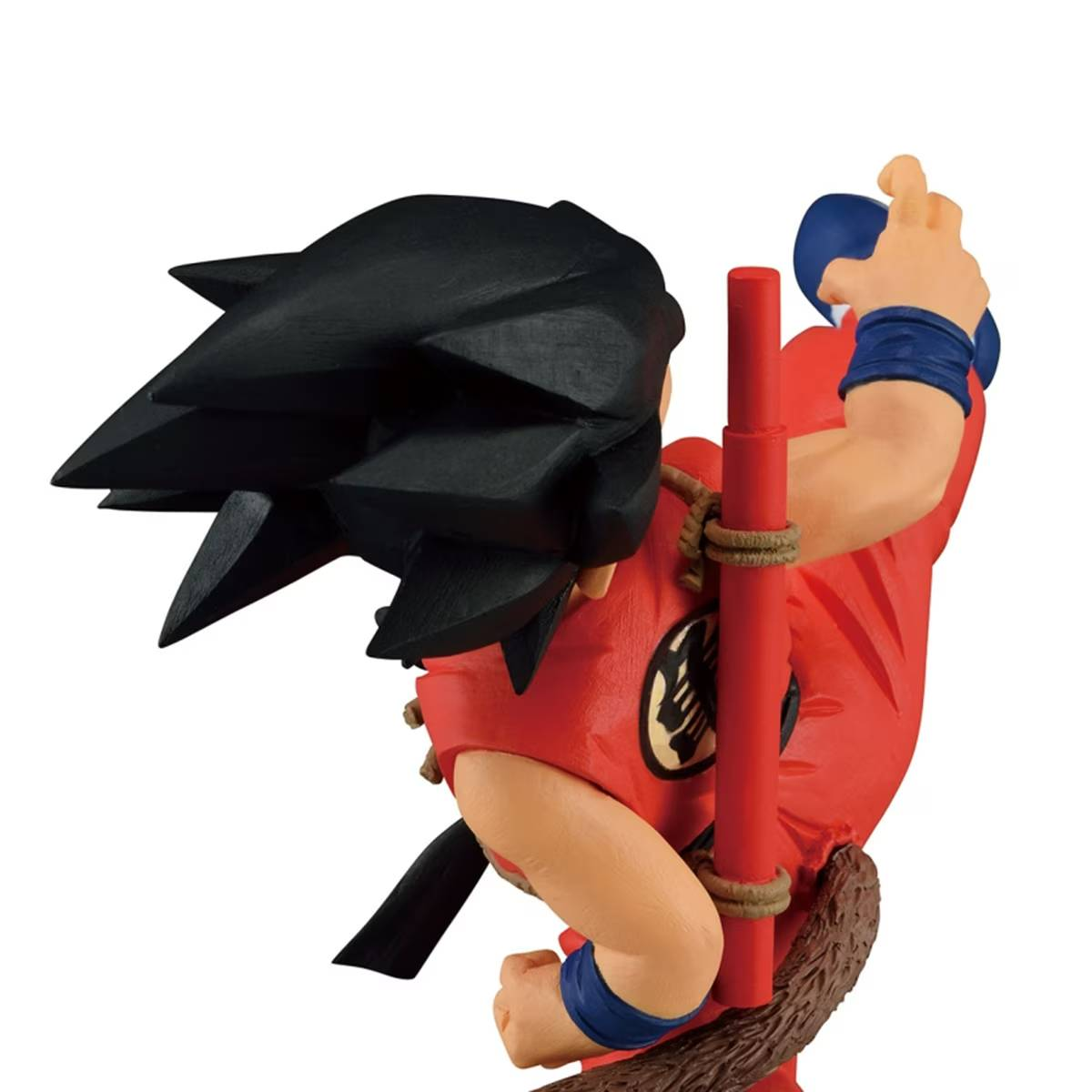 Figura de Goku con gi rojo, pelo negro puntiagudo, sosteniendo un bastón, listo para pelear.
