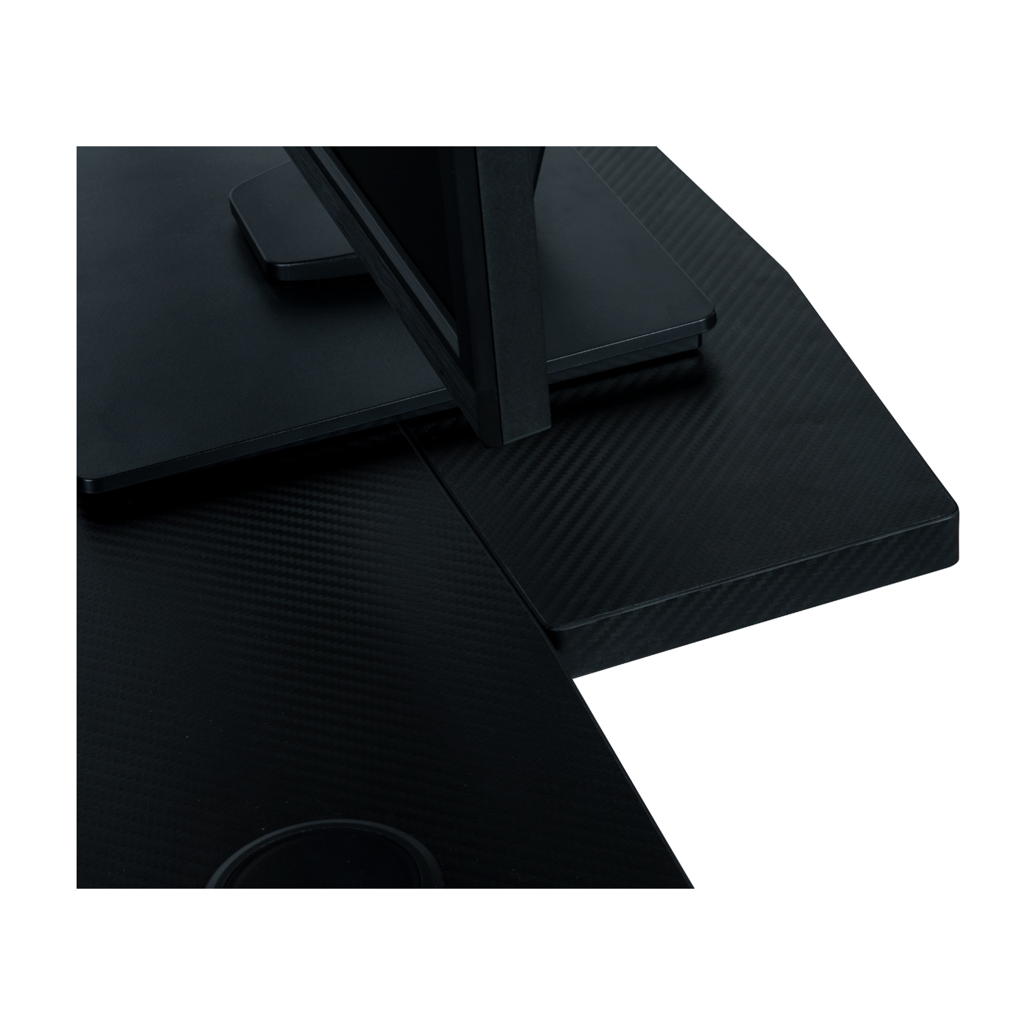 Primo piano di una superficie di scrivania nera, con supporto per monitor e foro per cavi.