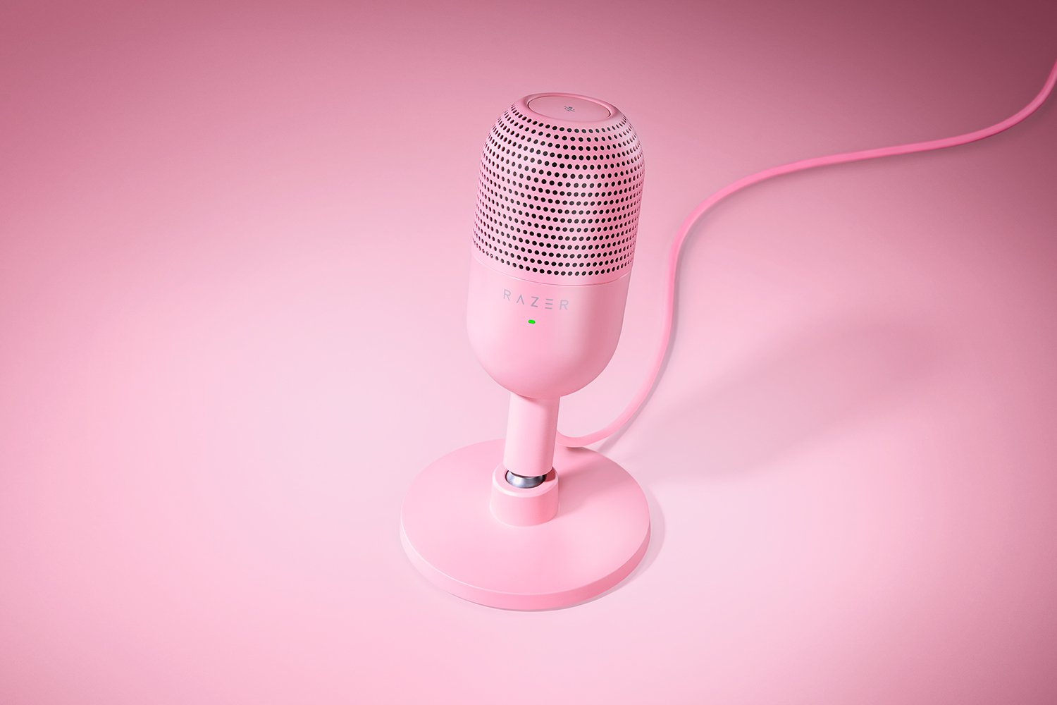 Microfono rosa su un supporto, posto su una superficie rosa, con un filo rosa.