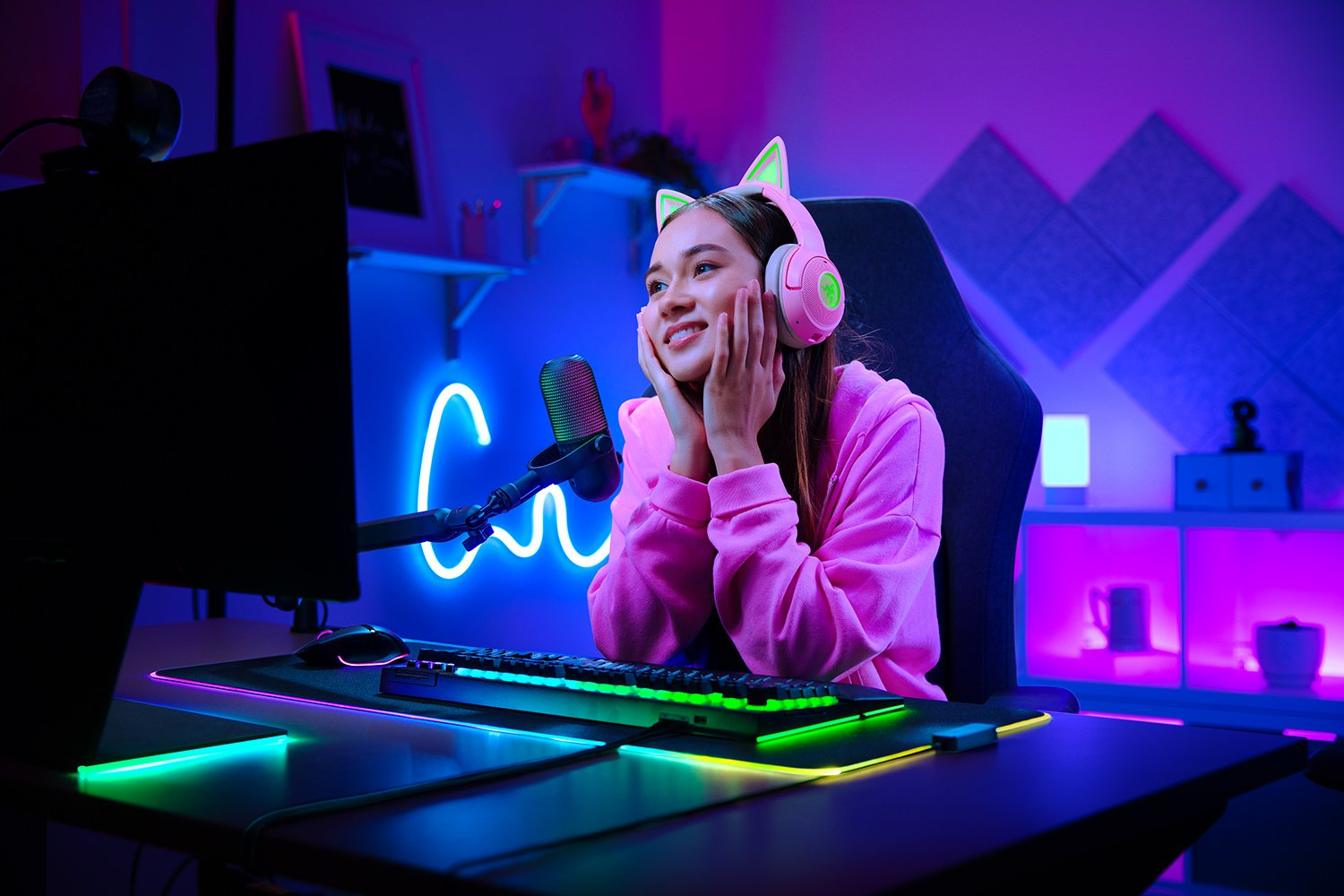 Ein Mädchen mit Kopfhörern sitzt an einem Schreibtisch und streamt live mit einer Kamera.
