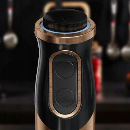 Zbliżenie czarnego i złotego blendera z przyciskami.