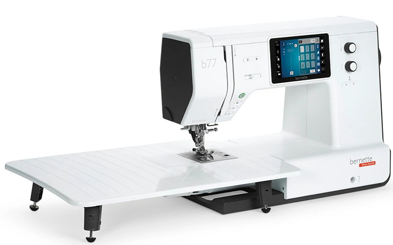 Biała maszyna do szycia z dużym płaskim łożem. Ekran pokazuje interfejs.