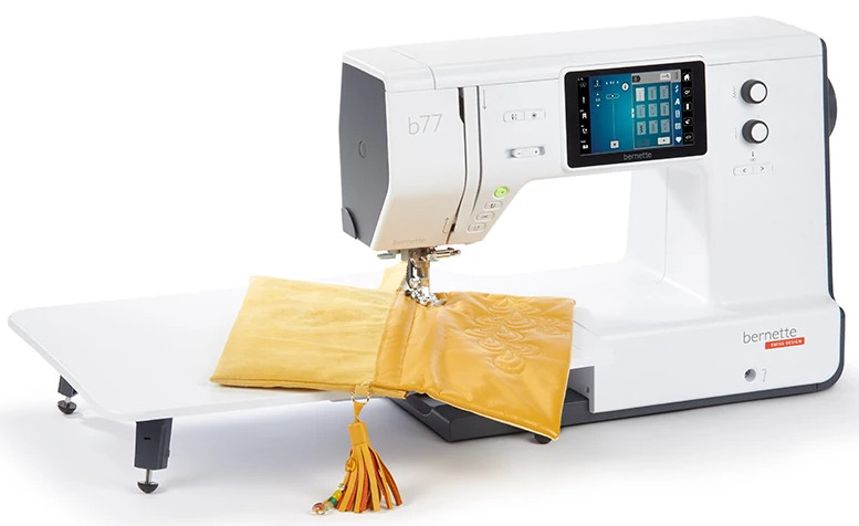 Biała maszyna do szycia z żółtą tkaniną i małym stołem.