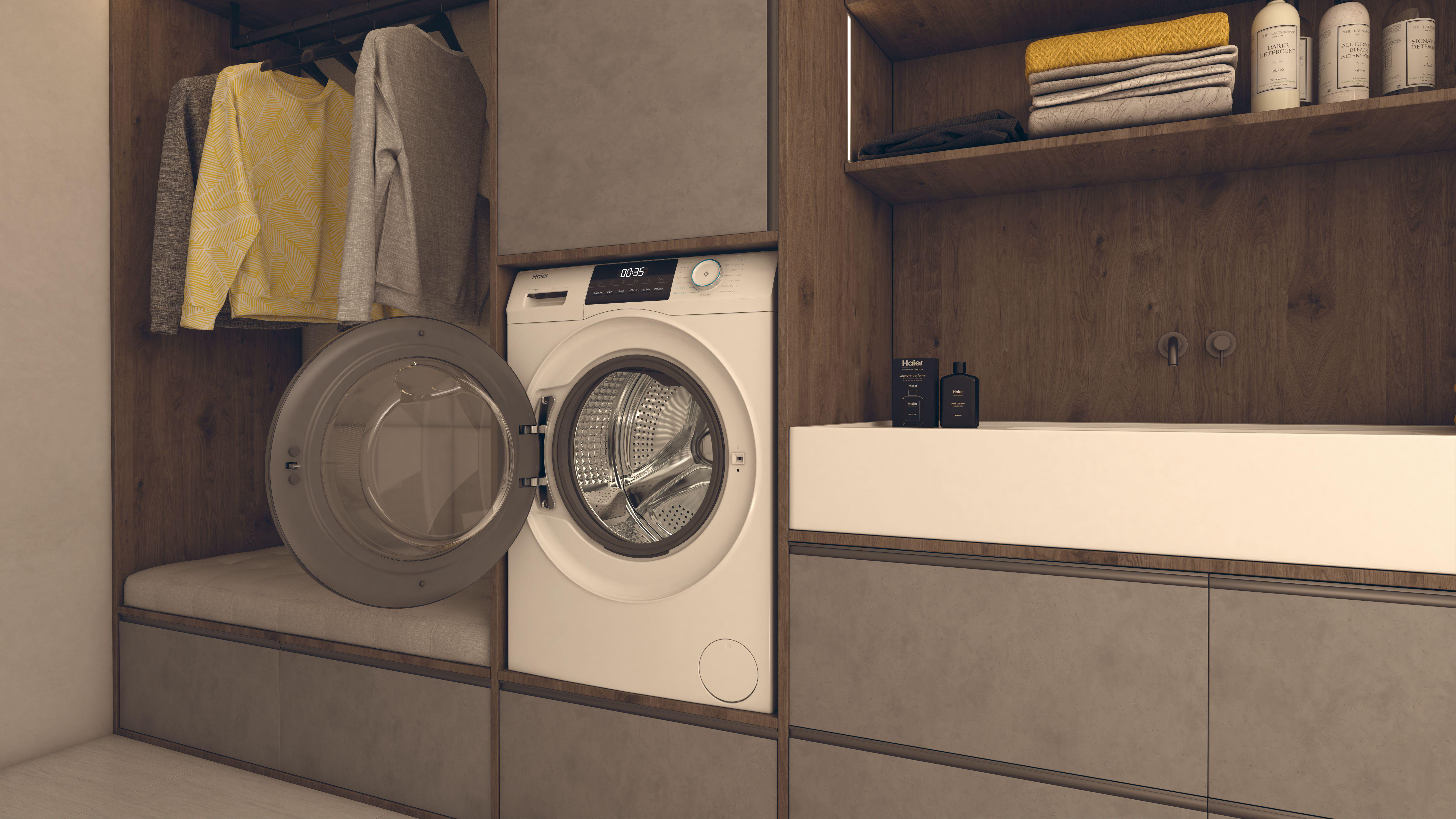 Waschküche mit offener Waschmaschine, Kleidung zum Aufhängen und Regalen mit Handtüchern und Toilettenartikeln.